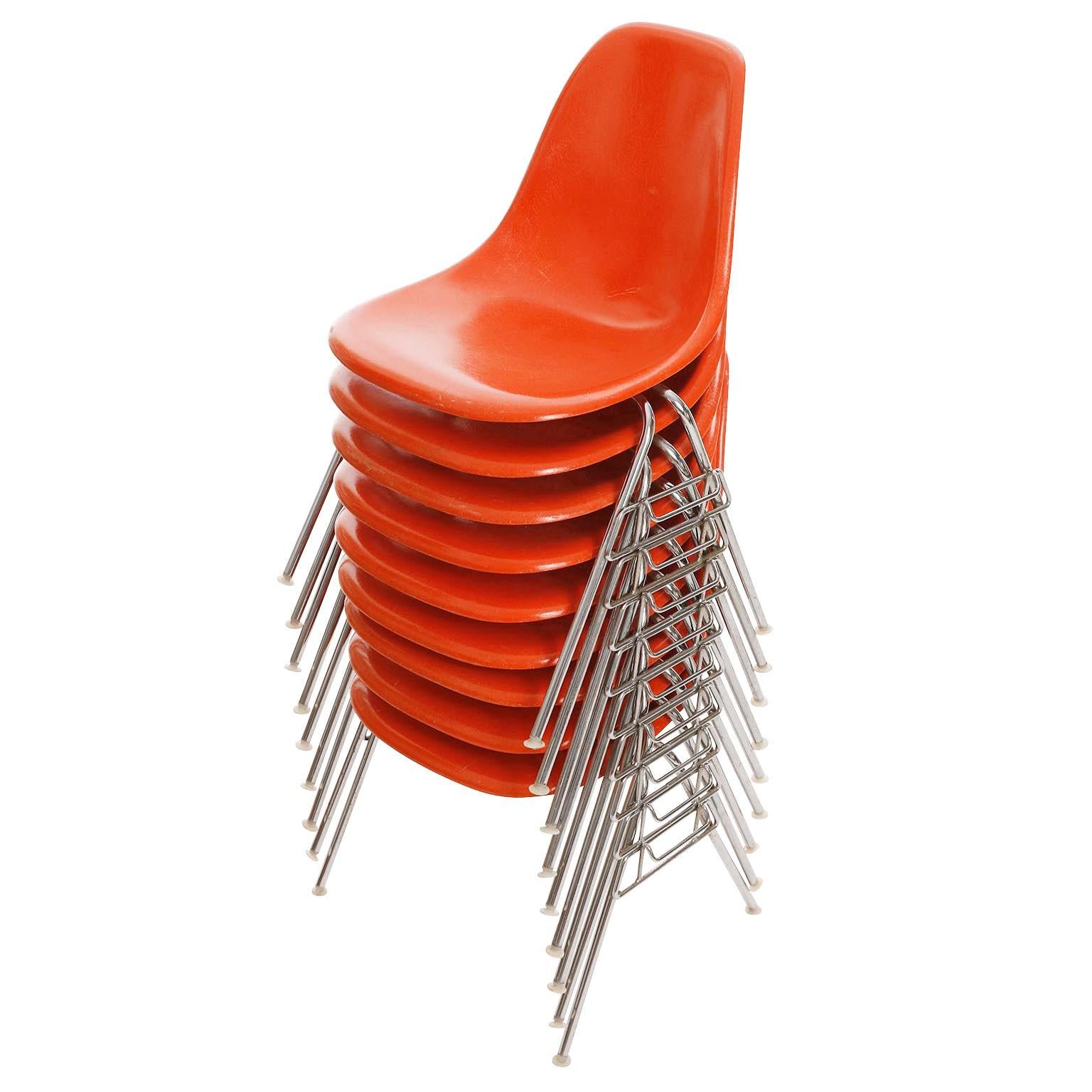 One of 18 stackable dining room chairs by Charles & Ray Eames for Herman Miller, manufactured in midcentury, circa 1970 (late 1960s or early 1970s).
The chairs are marked on the underside with 'herman miller'.
A molded orange fiberglass glass