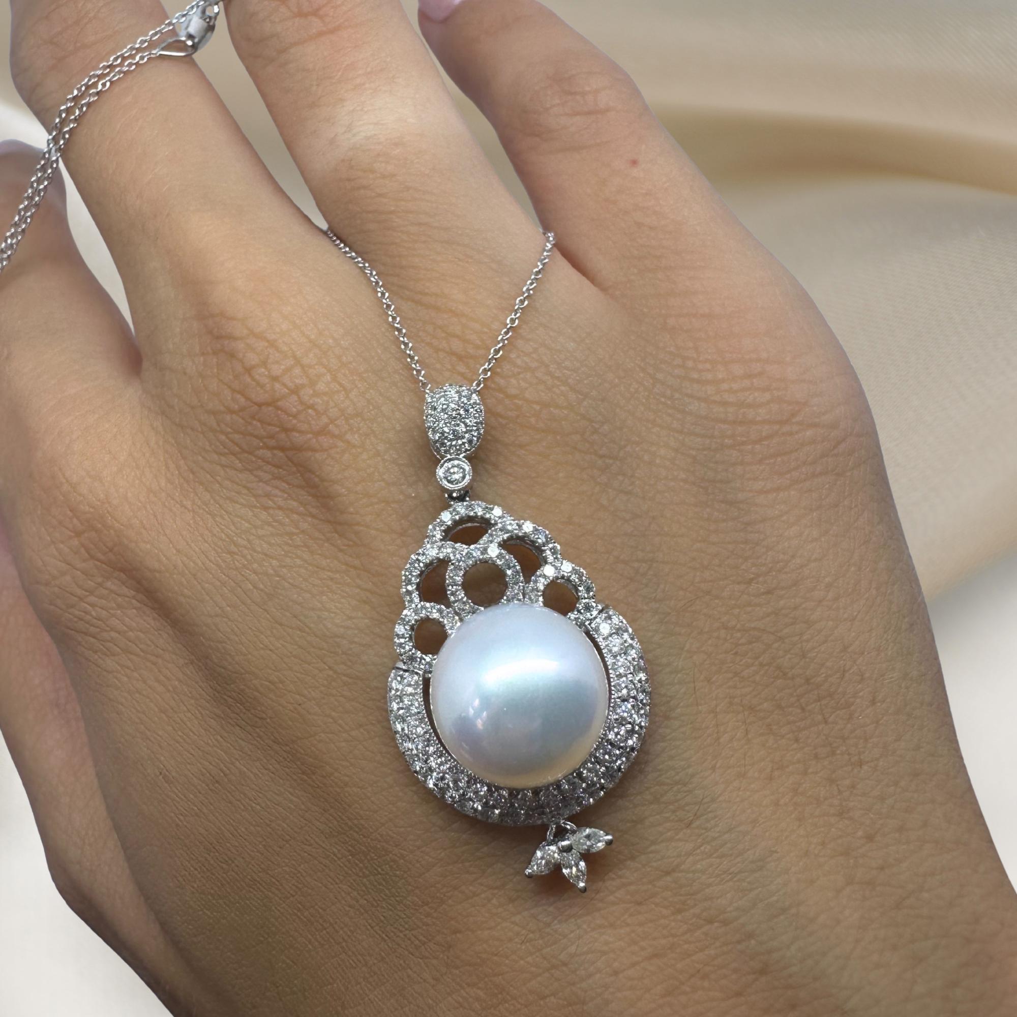 Este collar colgante de perlas y diamantes, expresión de refinada elegancia, está elaborado en oro blanco de 18 quilates. Los diamantes talla brillante (0,75 quilates en total) enmarcan delicadamente una luminosa perla blanca redonda, creando un
