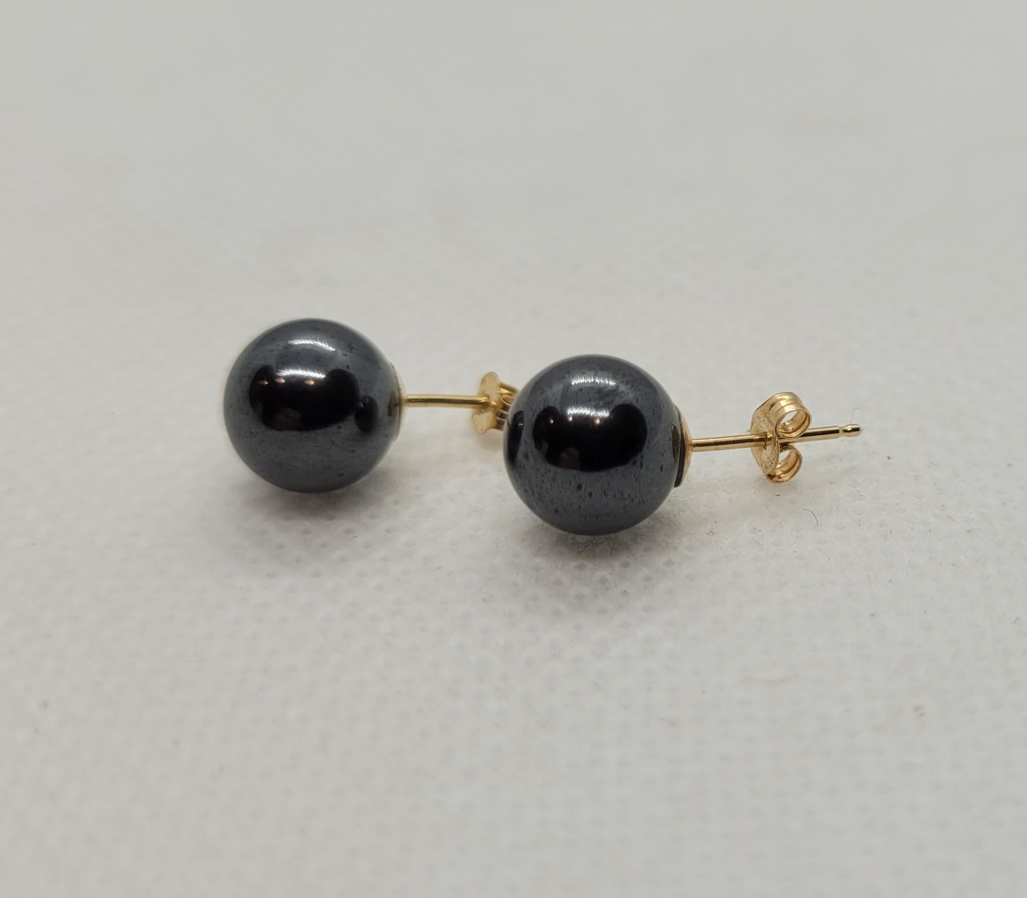 This exquisite jewelry set features a stunning necklace crafted from 14k yellow gold, adorned with beautifully polished 8.3mm round hematite beads. Each bead is meticulously knotted for added elegance and security. The necklace is completed with a