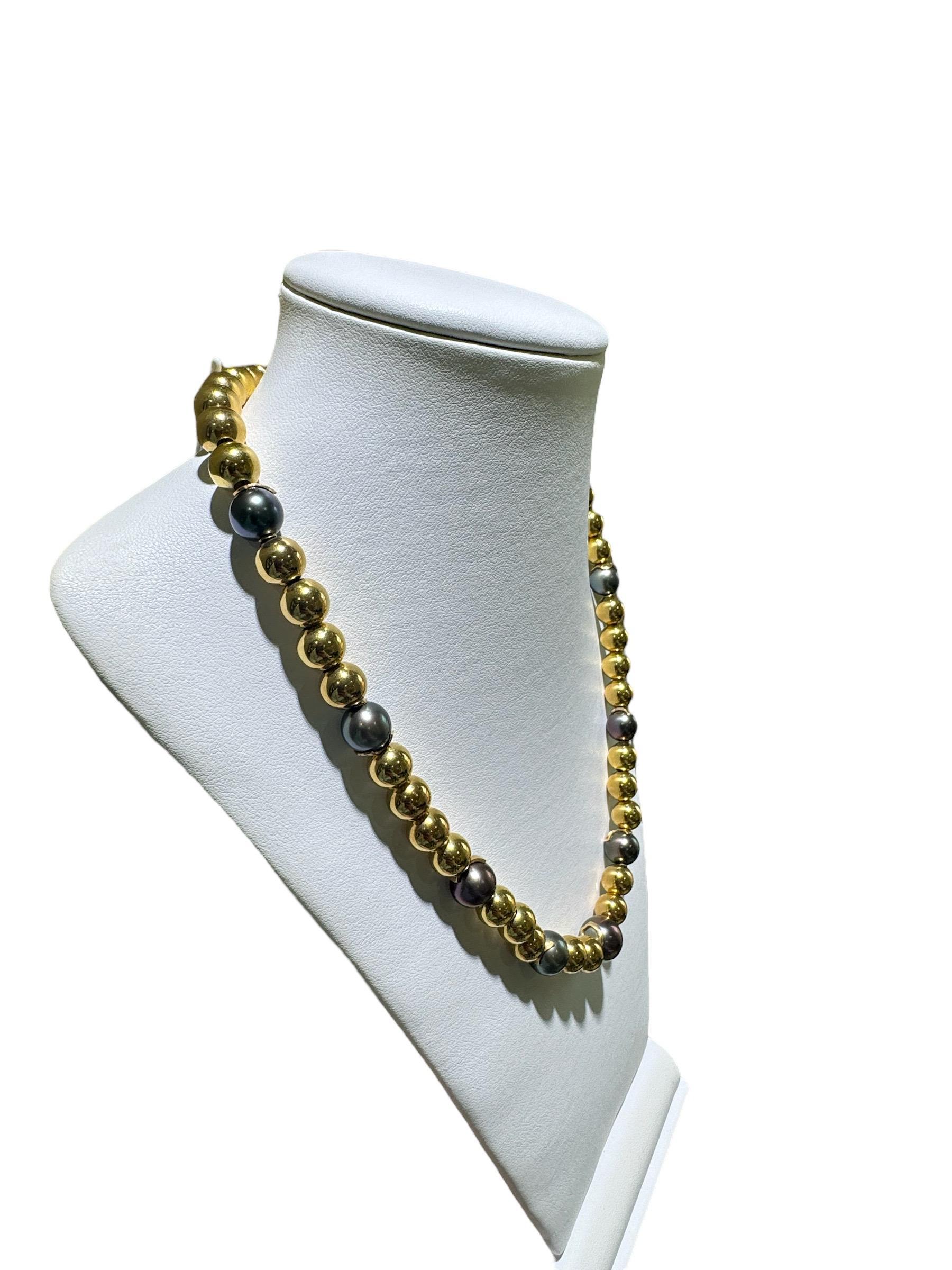 We have never seen this unique combination of pearls & gold beads.
This stunning necklace is composed of 7 Black / Grey Tahitian Pearl ranging in size from 11.5mm - 9.5mm.
The pearls are accented with 43 - 9mm 14K Yellow Gold Round Ball