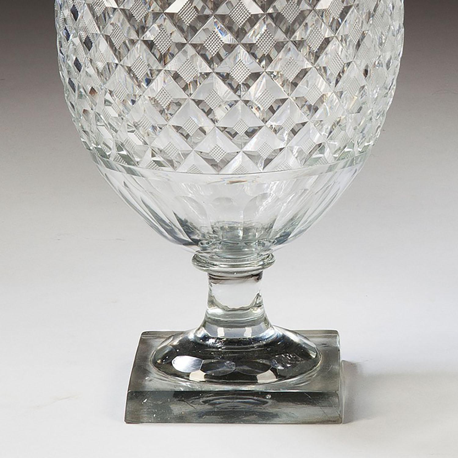 A pair of cut glass over scale fruit coolers from the Belgian Voneche works with boldly diamond cut and facetted bodies and covers. Standing on faceted stem feet.
Belgium, circa 1830

Measures: Height 18 in (45cm), width 8 in (20cm).