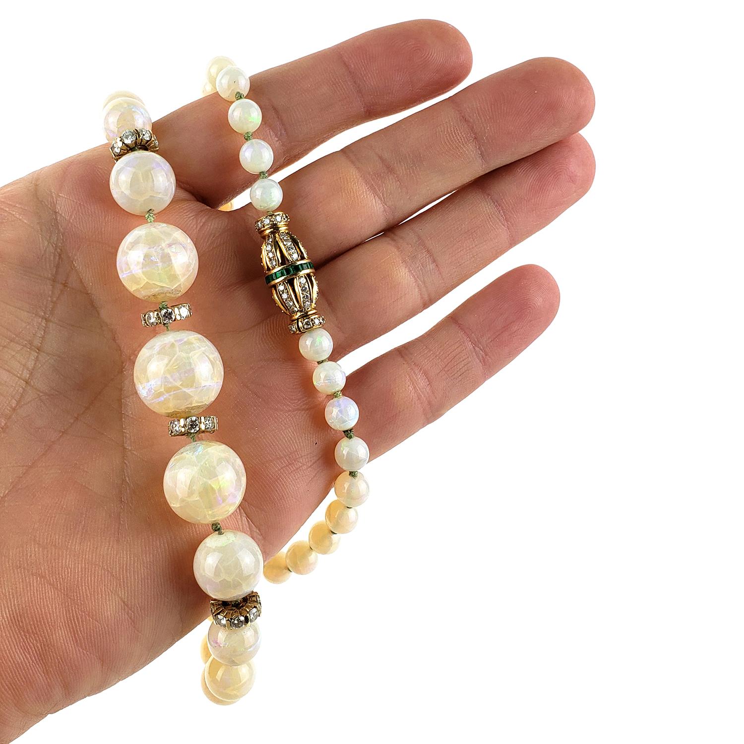18 inch Opal necklace with round polished opals that measure from 16 mm to 6.5 mm, offset by 4 diamond roundels and beautifully connected with a 18k yellow gold clasp that contains .35cts of Columbian colored Emeralds and rbc diamonds that are clean
