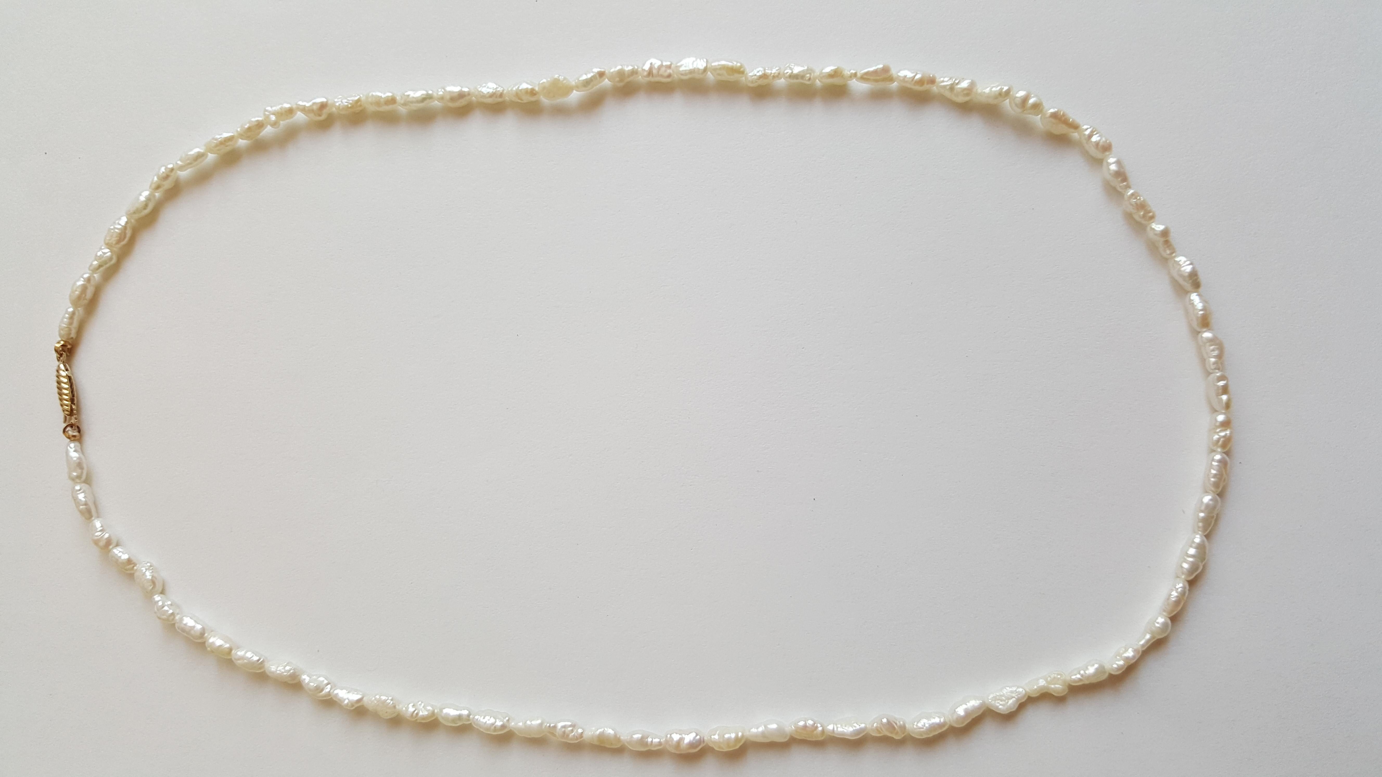 Modern White Freshwater Pearl Strand with 14kt Yellow Gold Pearl Clasp For Sale