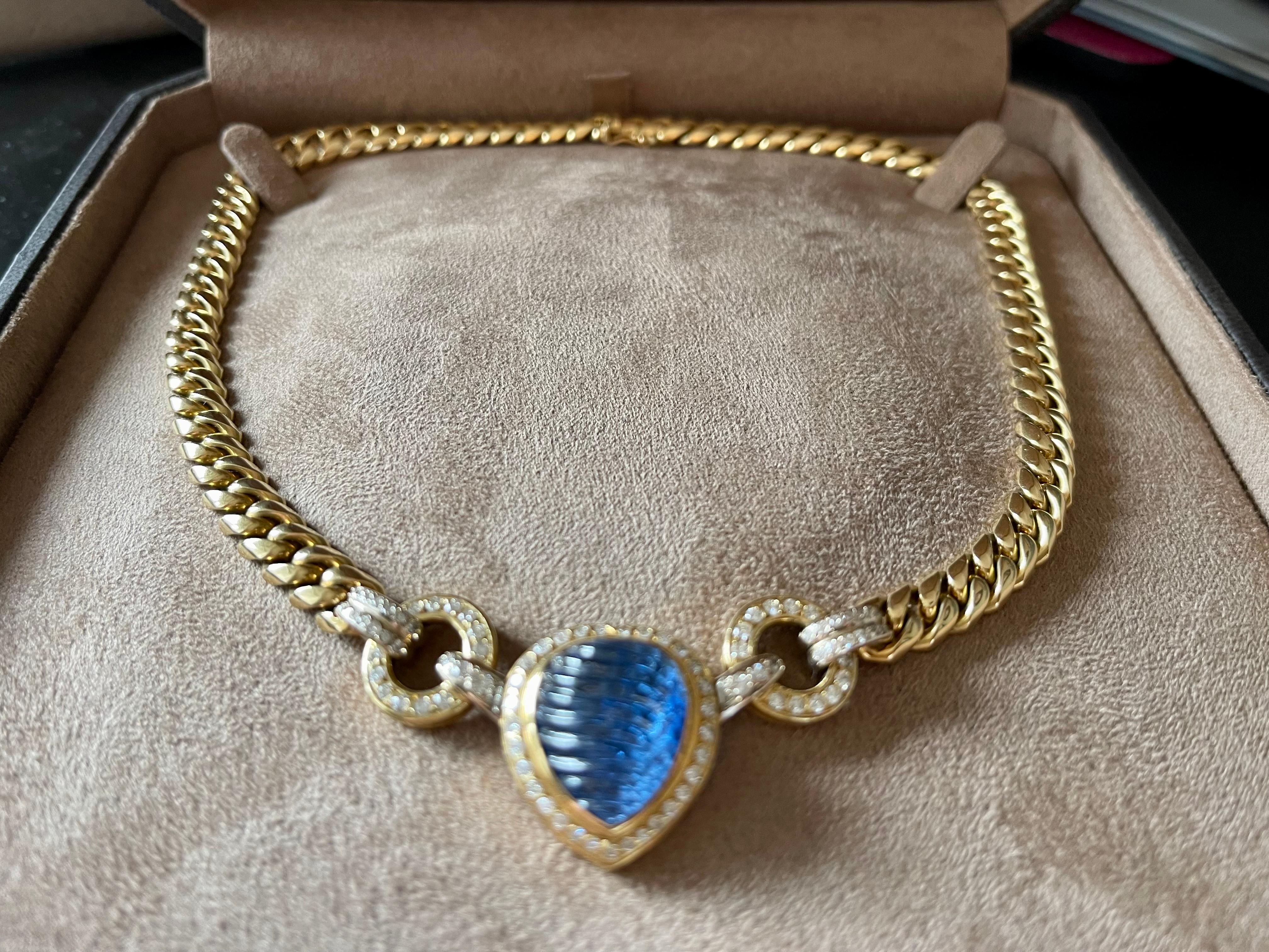 A timeless handcrafted 18 K cuban link Necklace set with a pear shape blue Sappire Cabochon weighing approximately 10 ct, surrounded by brilliant cut Diamonds. Very nice workmanship, solid 18 K yellow Gold. Length: 41 cm. Weight: 97.20 grams. 
The
