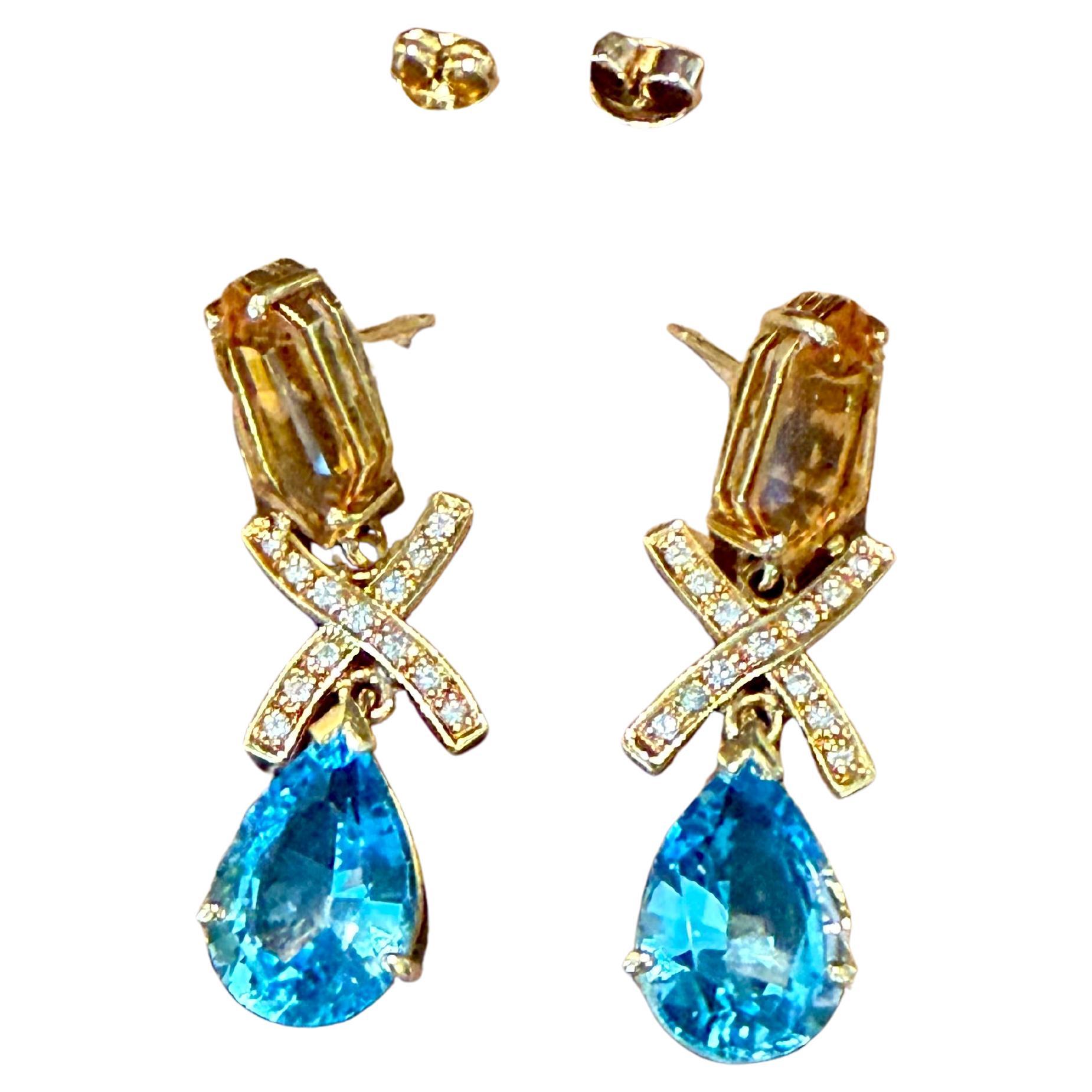 Longues boucles d'oreilles élégantes et minimalistes de design géométrique en or jaune 18 K avec 2 citrines de taille fantaisie, 2 topazes bleues en forme de poire et 26 petits diamants.
Les boucles d'oreilles mesurent 4.50 cm de long. Poids : 15,77