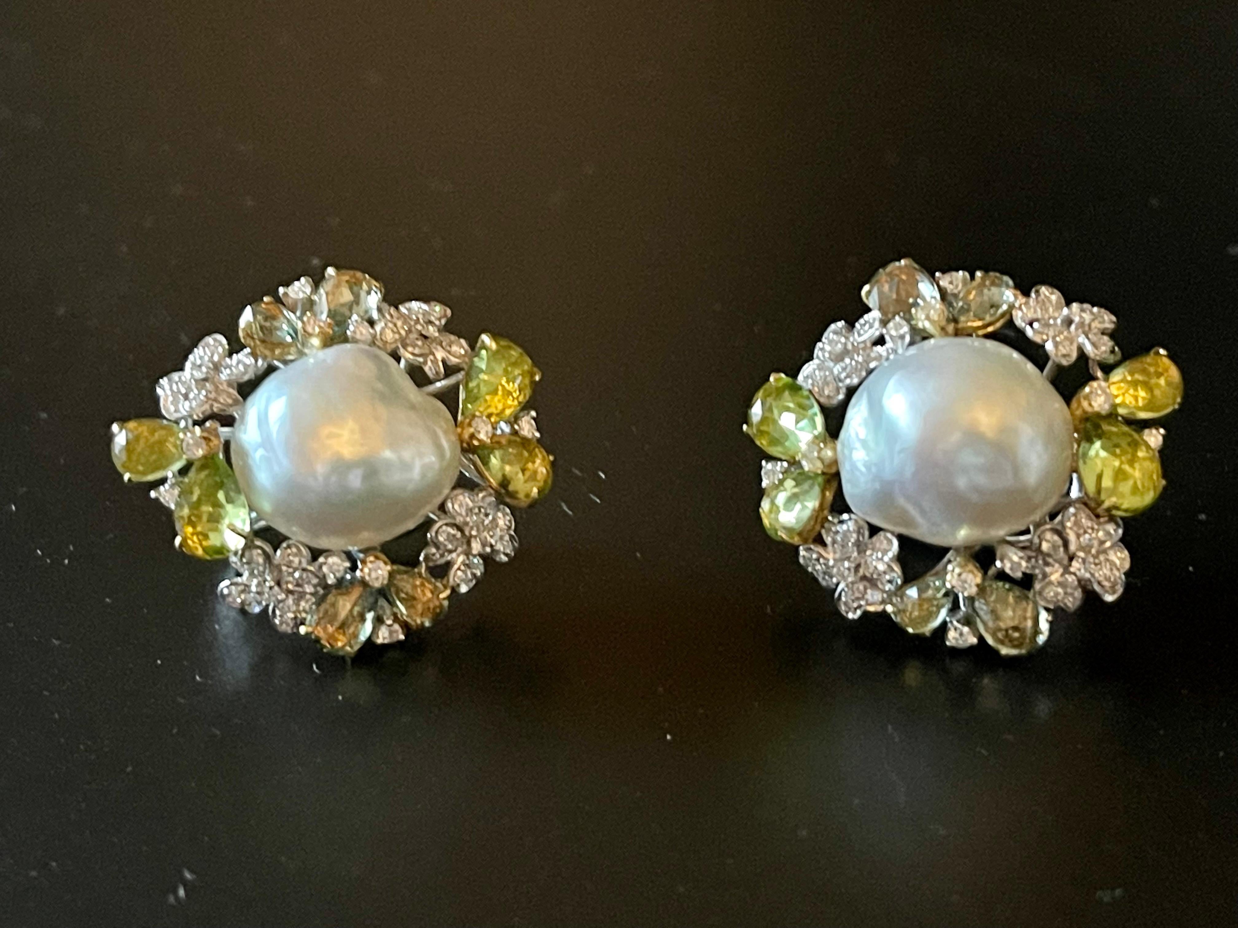 A pair of very lovely 18 K white and yellow Gold earclips featuring 2 white baroque South Sea Pearls surronded by 124 brilliant cut Diamonds, G color, vs clarity, 8 fancy cut green Sapphires weighing 2.80 ct and 8 fancy cut Peridots weighing 0.59
