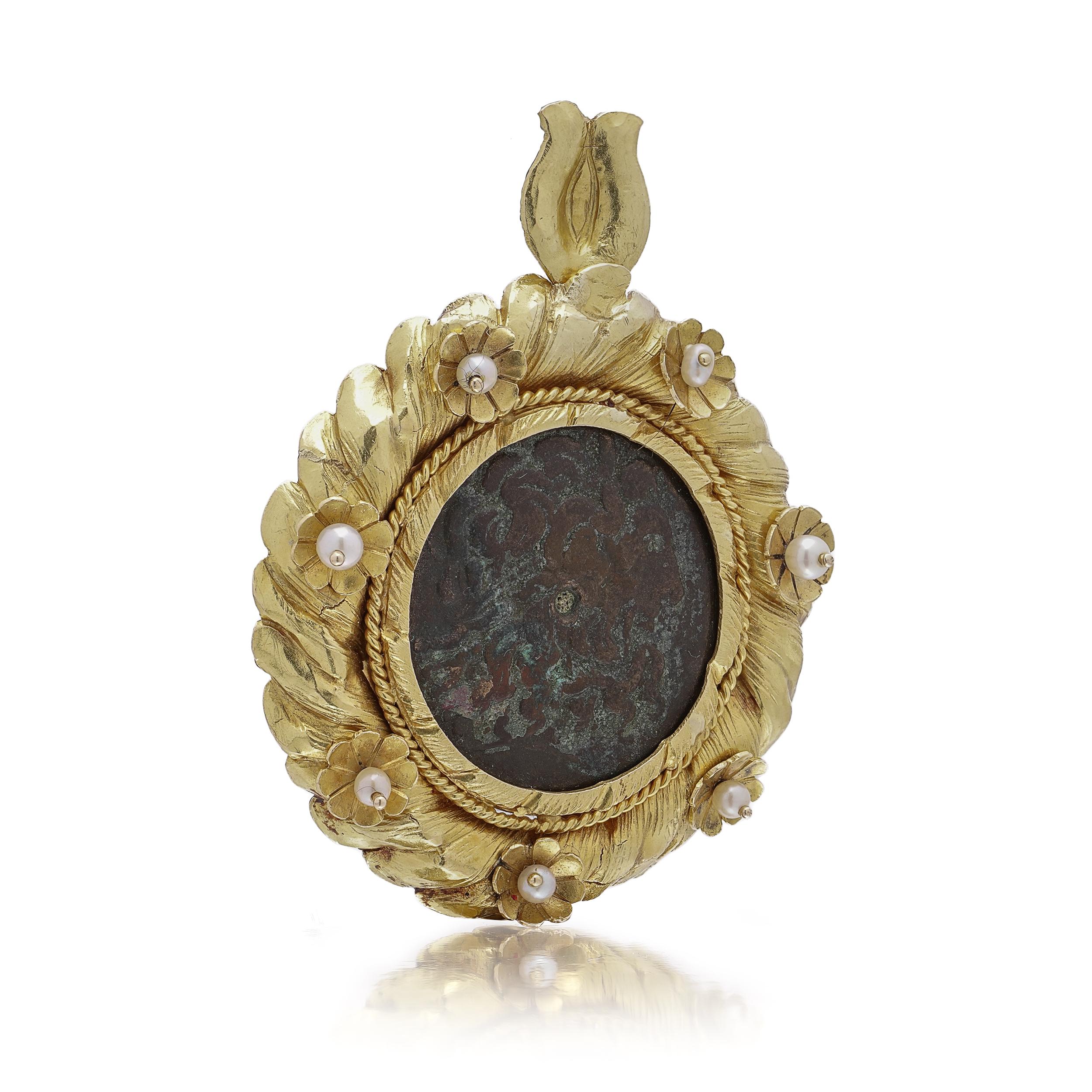 Make & Model: Ornate pendant, 18 kt yellow gold, featuring a genuine Ptolemaic bronze coin

Weight: 64 g

Diameter: 5.5 cm
Pearls: 7 round cultured pearls, ~4 mm each
Pendant Hallmarked 750 and maker's mark.

Goldwork: Sculpted leaf motif