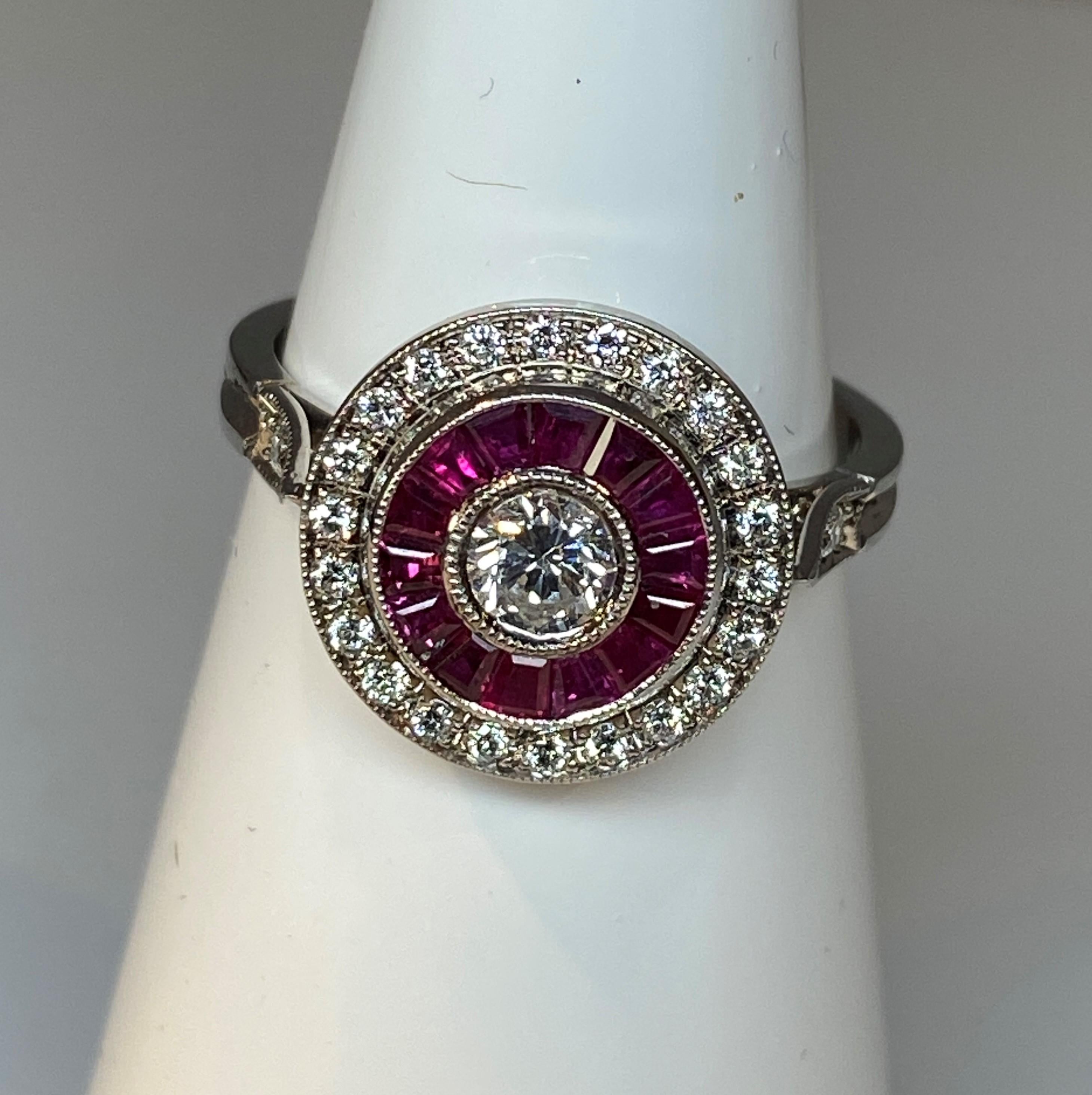 Ein wunderschöner, runder Brillantring aus 18 Karat mit einem Brillant von 0,25 Karat in der Mitte und einer Reihe von kalibrierten Rubinen von 0,84 Karat sowie einer Reihe von Brillanten von 0,21 Karat in der Mitte. Das Ensemble ist aus Perlmutt,