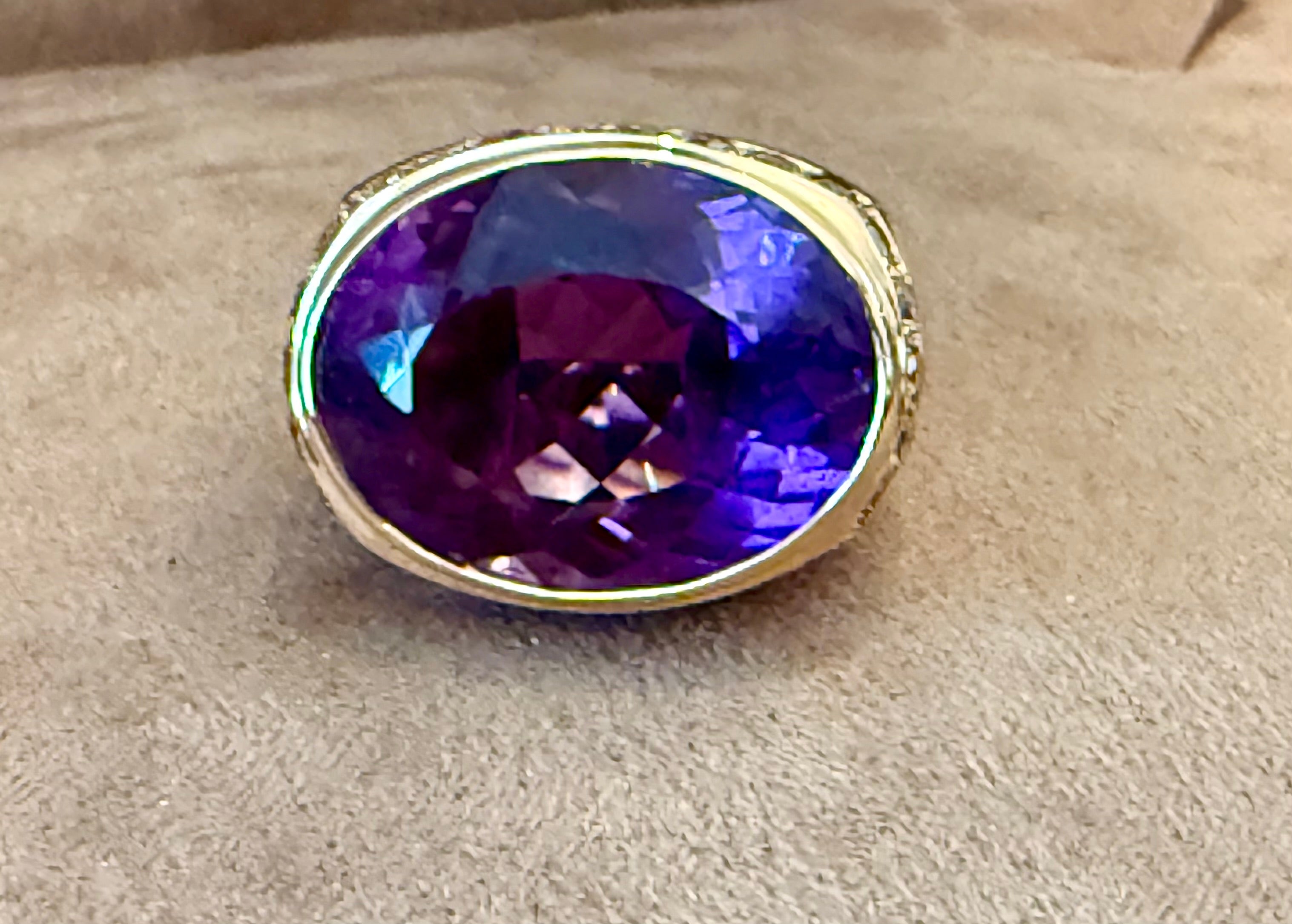Impresionante anillo de oro rosa de 18 quilates con una amatista ovalada de aproximadamente 19 quilates rodeada en los hombros por 28 diamantes talla brillante marrón de color champán y un peso aproximado de 2,20 quilates.
El anillo es actualmente