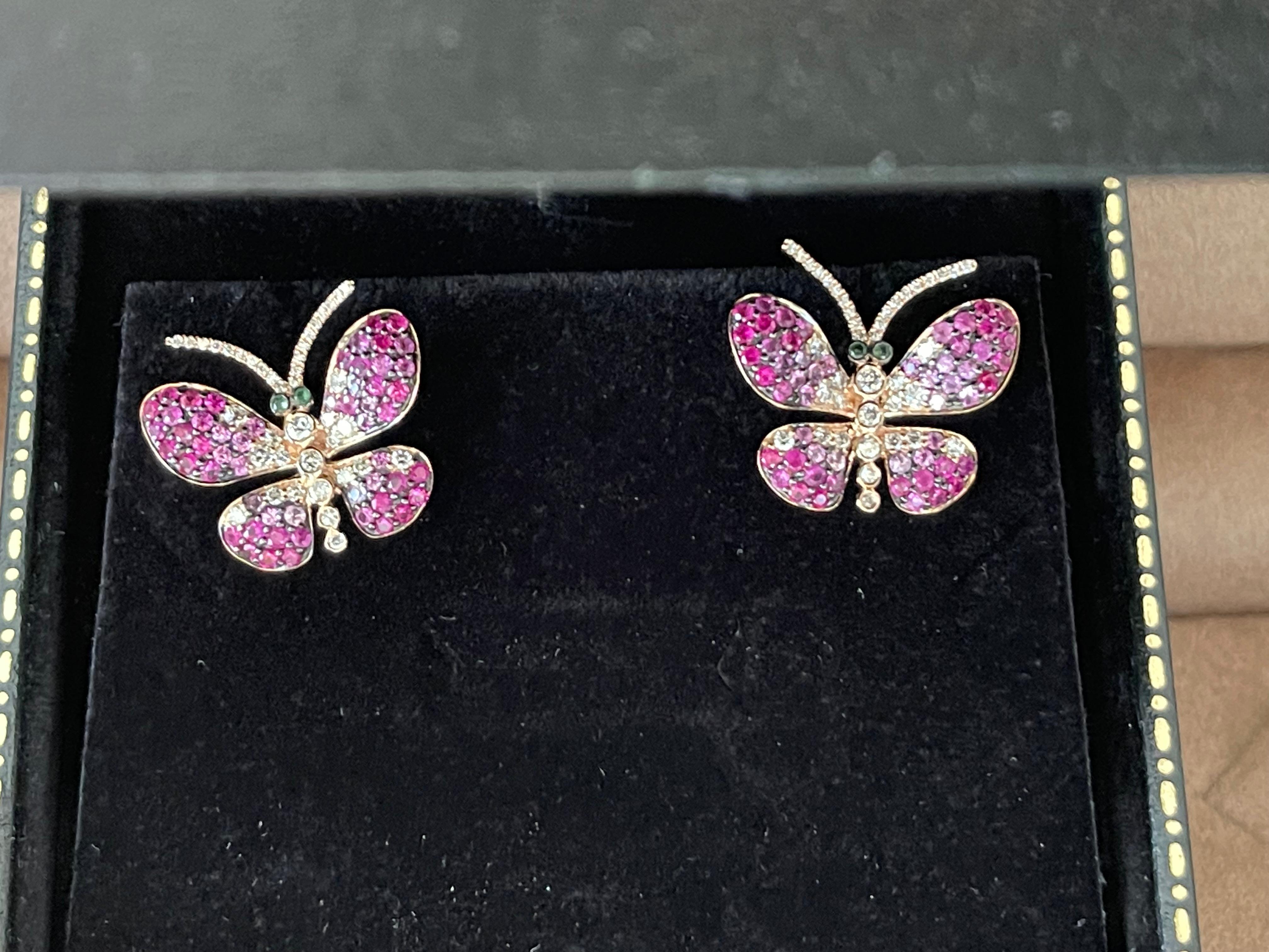 Une paire de boucles d'oreilles papillon en or rose 18 carats comprenant 78 diamants taille brillant pesant 0,67 ct, 32 saphirs roses pesant 0,51 ct, 75 rubis pesant 1,49 ct et 4 tsavorites pesant 0,04 ct. 
Dimensions : 2,16 cm x 2,10 cm : 2,16 cm x