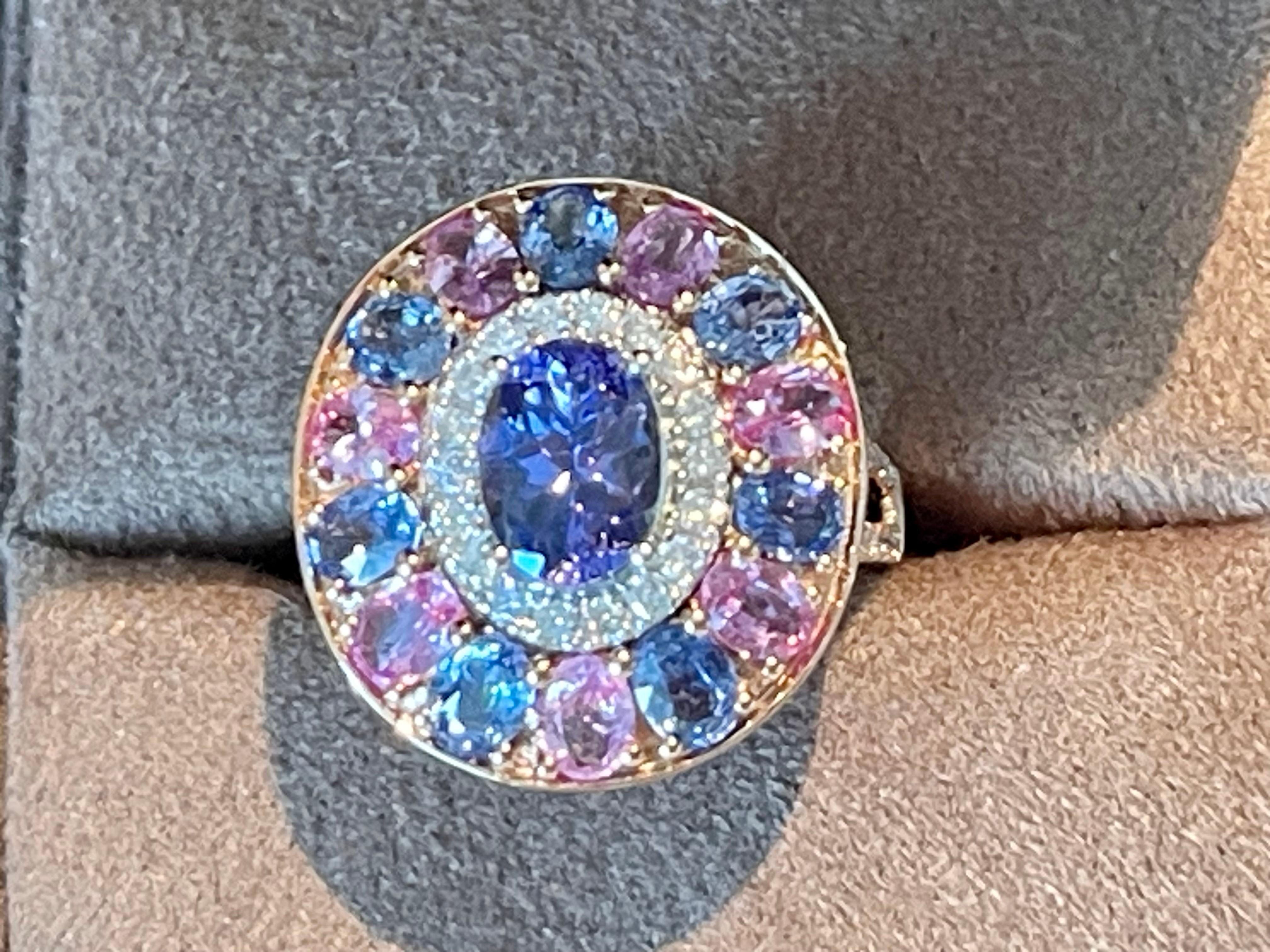 A truly a stunning display of color! These lovely and timeless Ring features a multi-color cluster of 1 oval Tanzanite weighing  1.28  ct, 7 skyblue Sapphires weighing 1.62 ct, 46 brillinat cut Diamonds weighing 0.38 ct and 7 pink Sapphires weighing