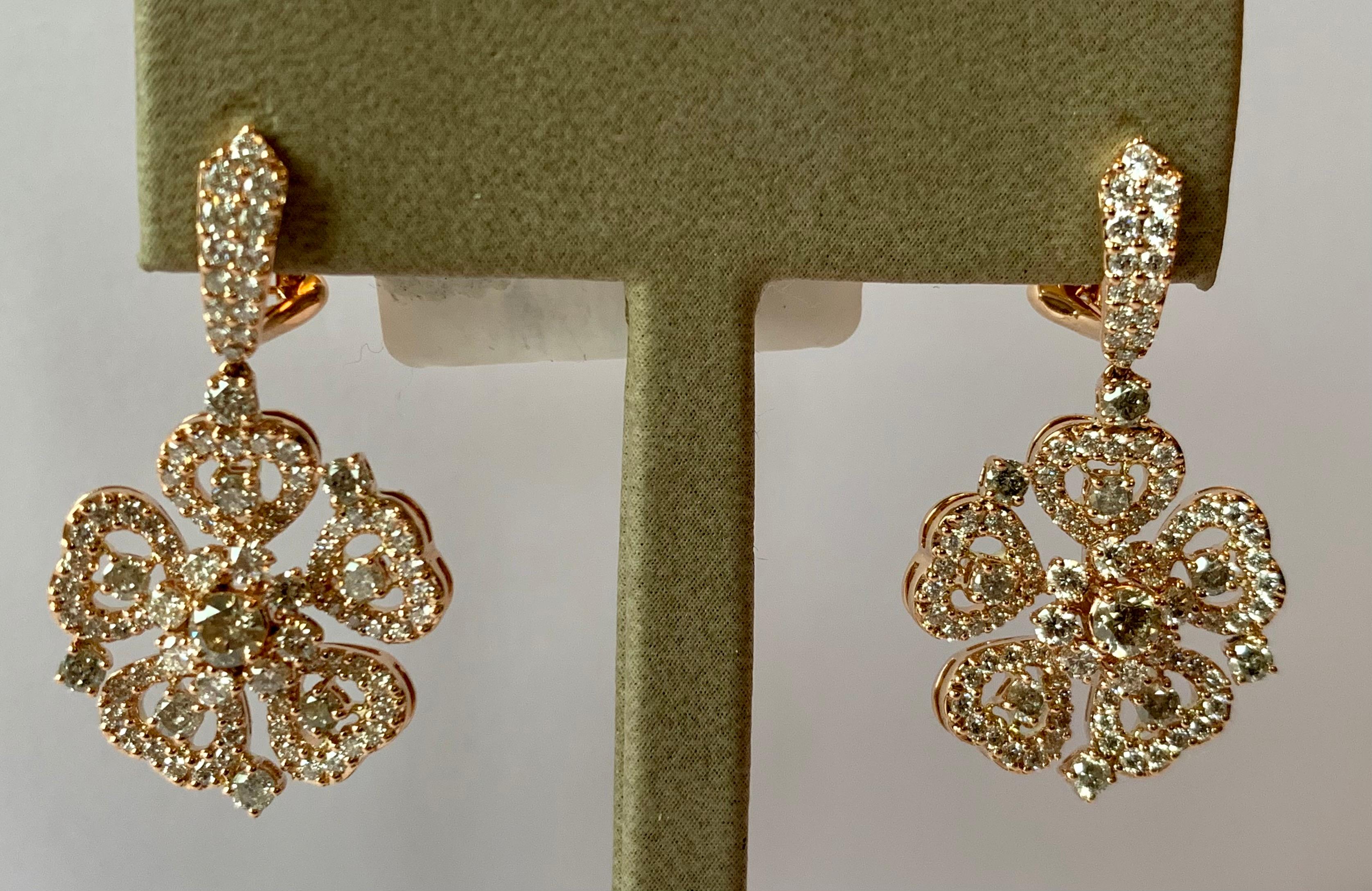Romantic and feminine 18 K rose Gold dangle omega clip post earrings with a stylized flower motif. Set with 204 white and champagne colored brilliant cut Diamonds weighing 3.31 ct. 
Matching Ring and pendants available!
Masterfully crafted piece!