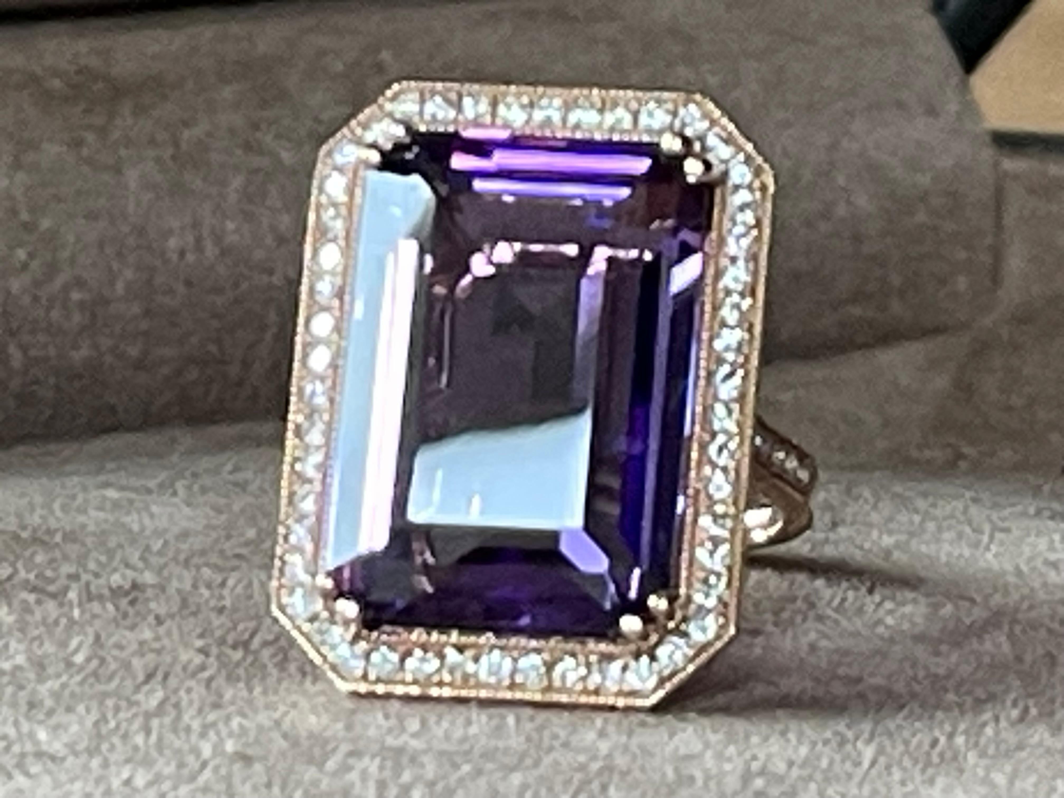 Stunning large prong set emerald cut Amethyst weiging 19.85 ct surrounded by 66 brilliant cut Diamonds weiging 0.65 ct. The intriguing colour of the Rose de France Amethyst with the elegant rose Gold gives a wonderful and fresh colour