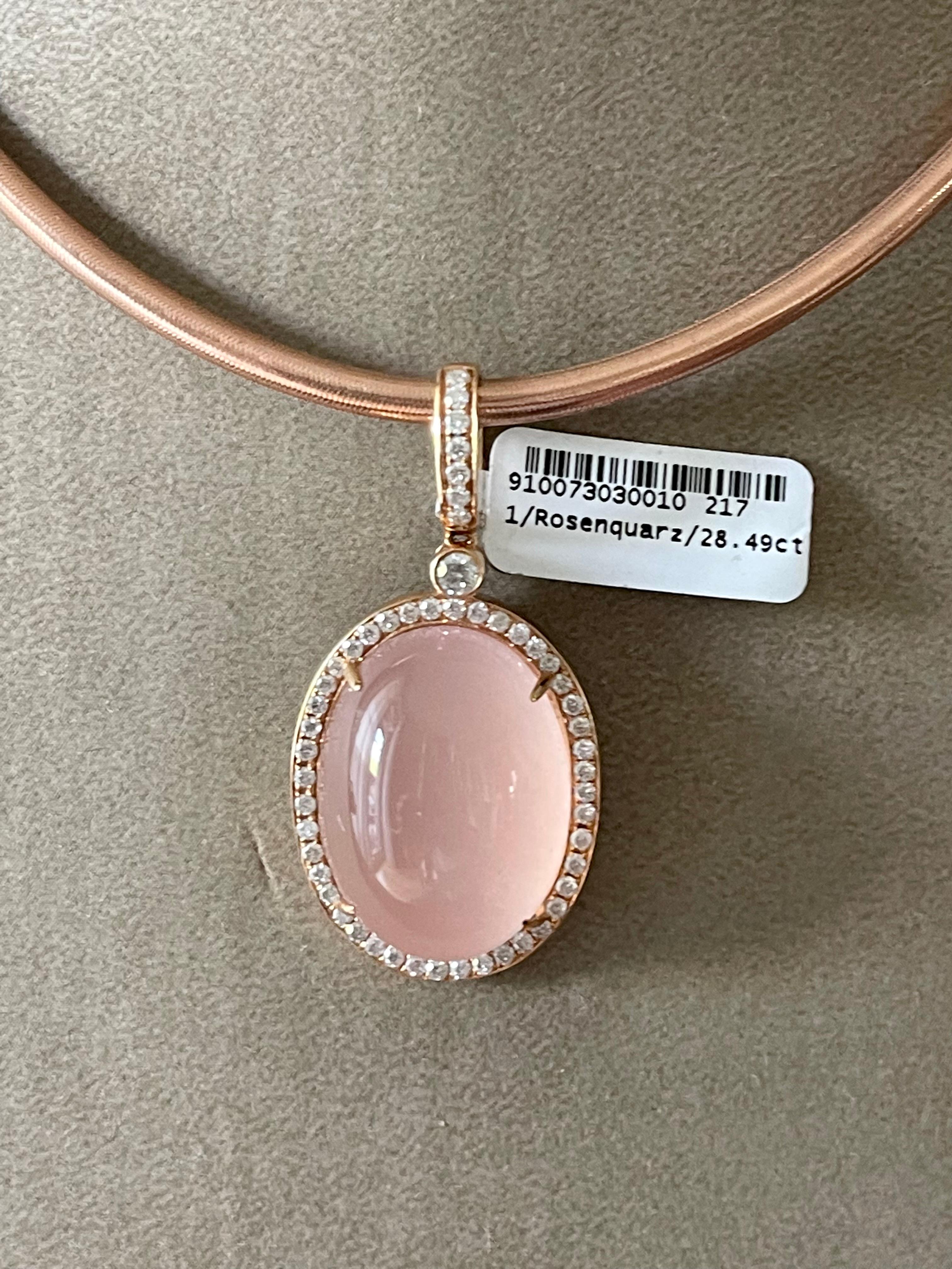 Beautiful and modern 18 K rose Gold pendant featuring a Rose Quartz Cabochon weighing 28.49 ct surrounded by 51 round brilliant cut Diamonds with a total weight of 0.75 ct. 
Length of the chain: 45 cm
Diemnsions of the pendant: 2 cm wide, length: 4