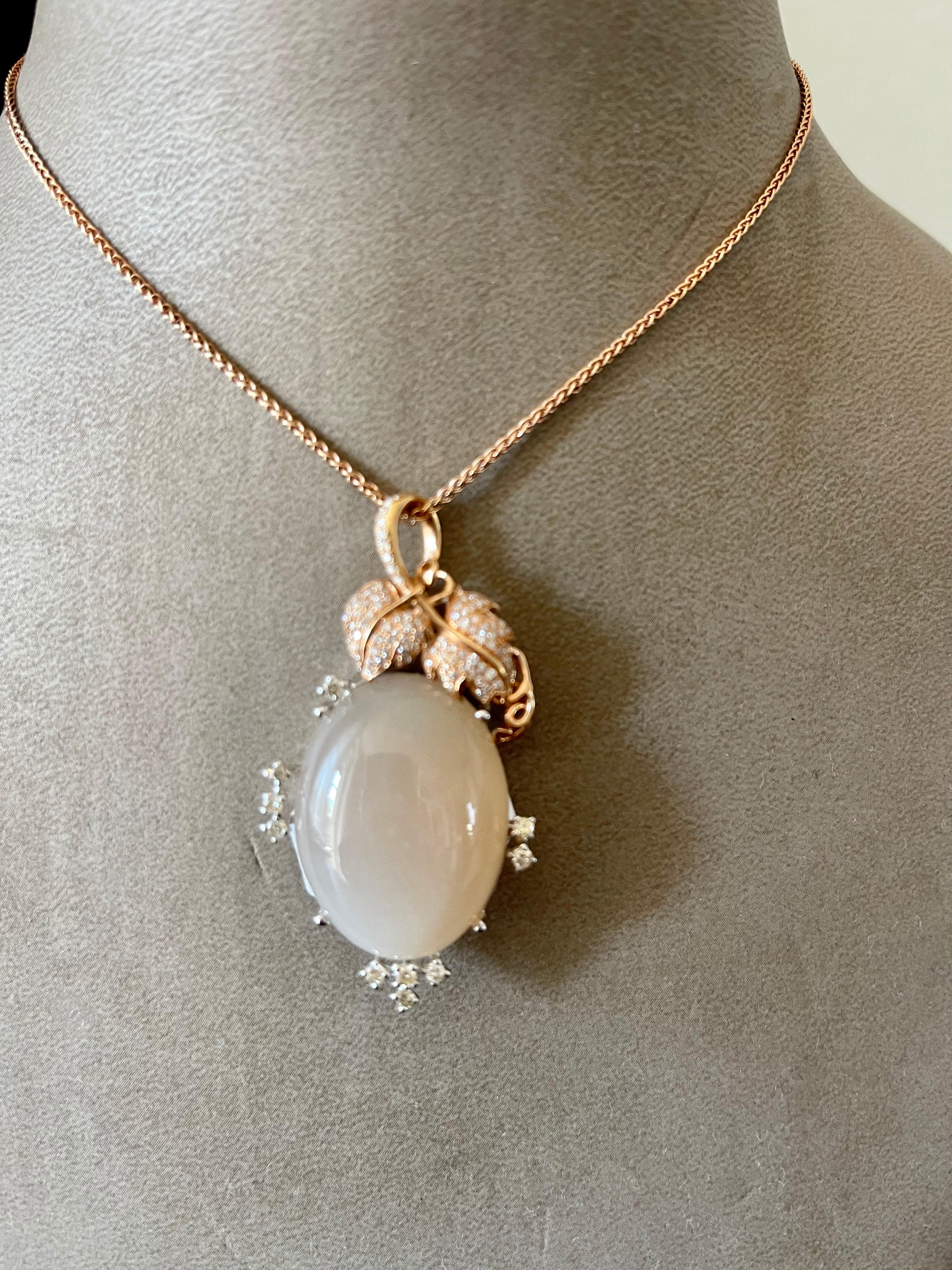 A very romantic and floral pendant featuring a brownish silvery moonstone Cabochon weighing 42.72 ct and decorated with 104 brilliant cut Diamonds weighing 0.64 ct. Set in 18 K white and rose Gold. The pendant comes with a timeless 18 K rose Gold
