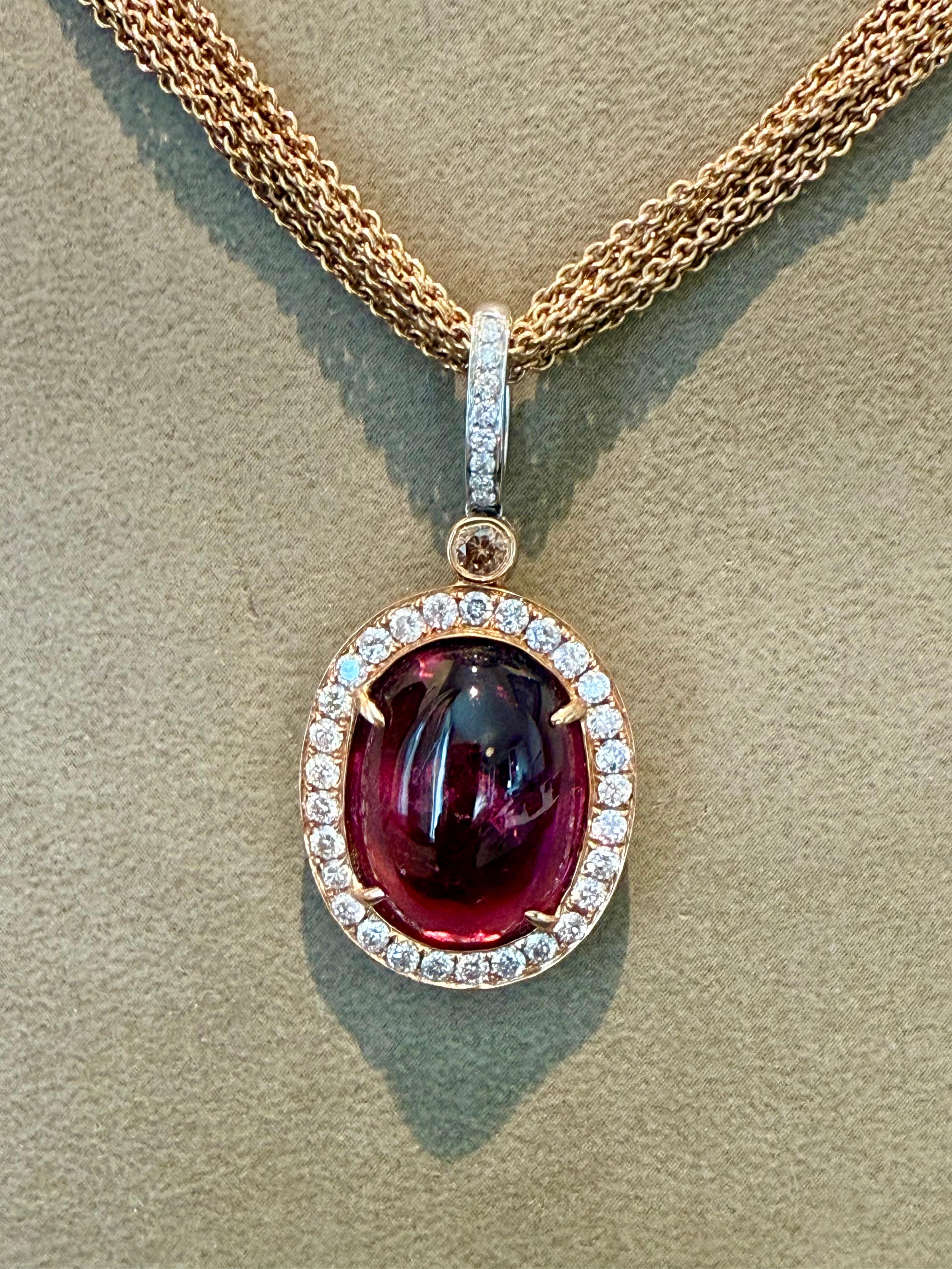 An 18 K rose Gold necklace consisting of 7 fine Anchor Chains. Length of necklace 42 cm. Weight of necklace: 24.33 grams.
Pendant in 18 K rose and white Gold featuring a lovely Rubellite Cabochon weighing ca. 9 ct and 38 white brilliant cut Diamonds