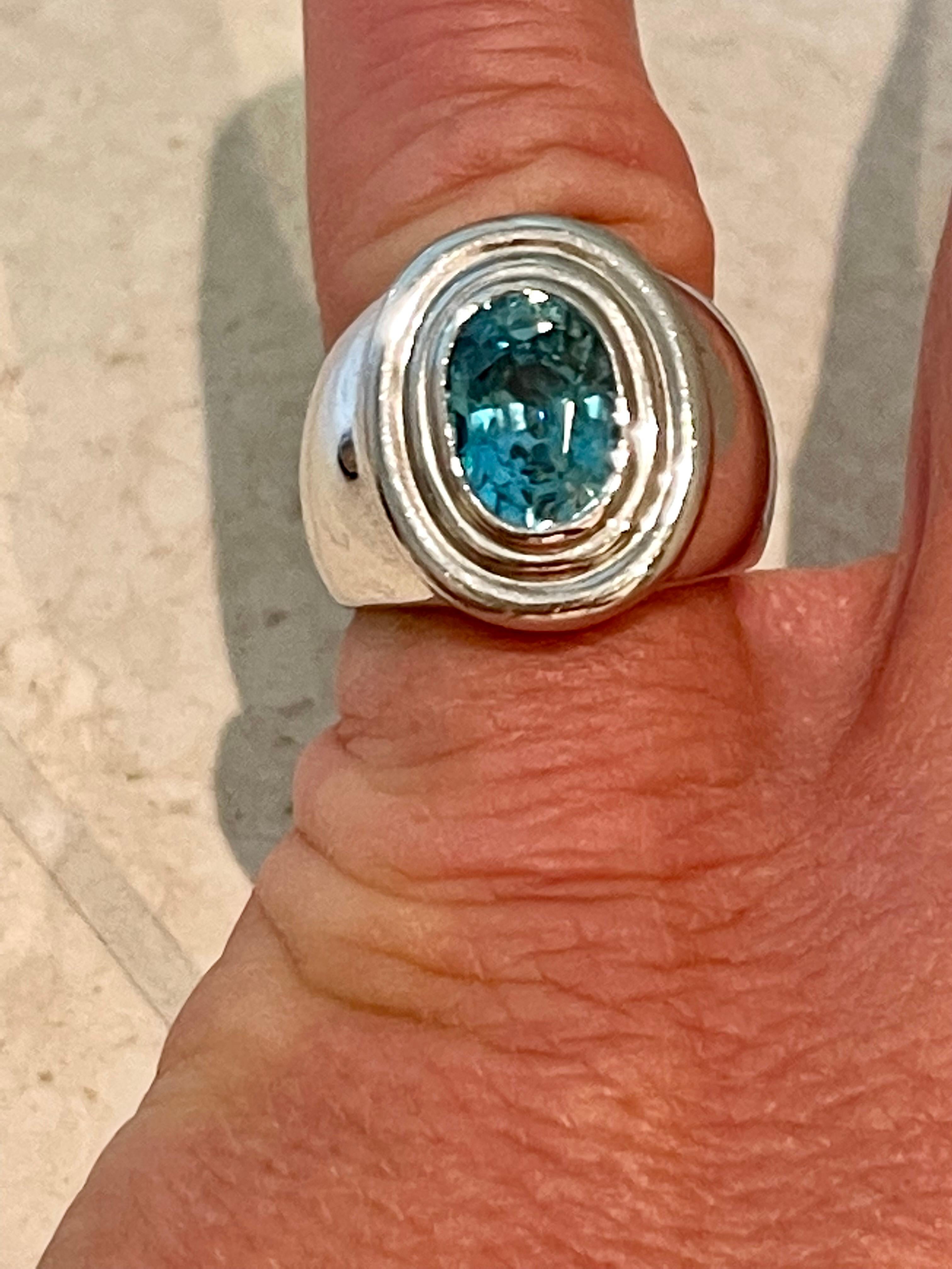 Solid and timeless 18 K white Gold Band Ring featuring a bezel set blue Zircon weighing 5.15 ct. 
The ring is currently size 15/55( american ring size 7 1/2) but can easily be resized. 
Masterfully handcrafted piece! Authenticity and money back is