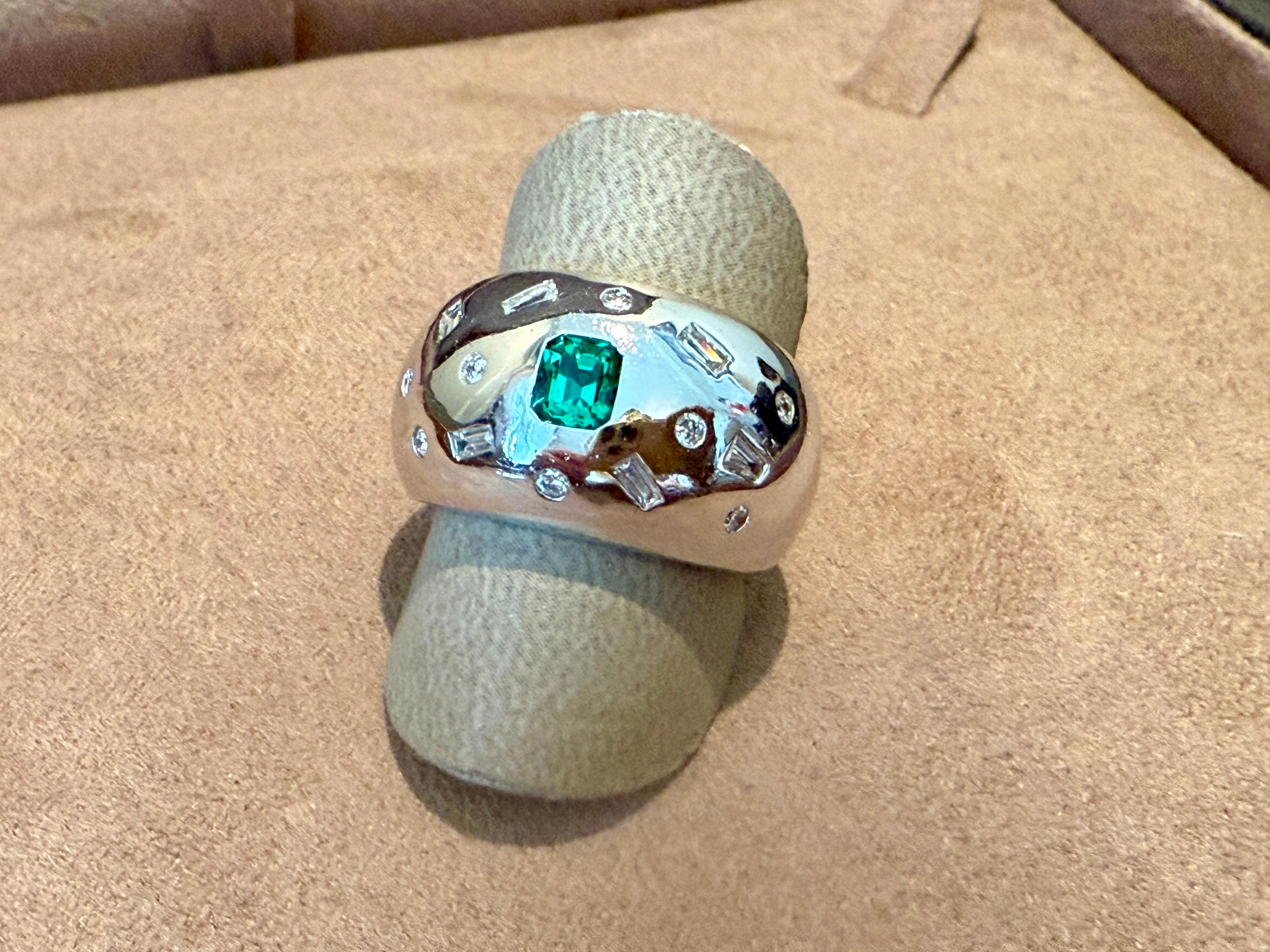 Anello a fascia in oro bianco 18 K., sportivo ed elegante, con smeraldo centrale di circa 0,95 carati. La bellezza della  Lo smeraldo verde vivo è impreziosito da piccoli diamanti taglio baguette e taglio brillante. Una lavorazione molto solida con