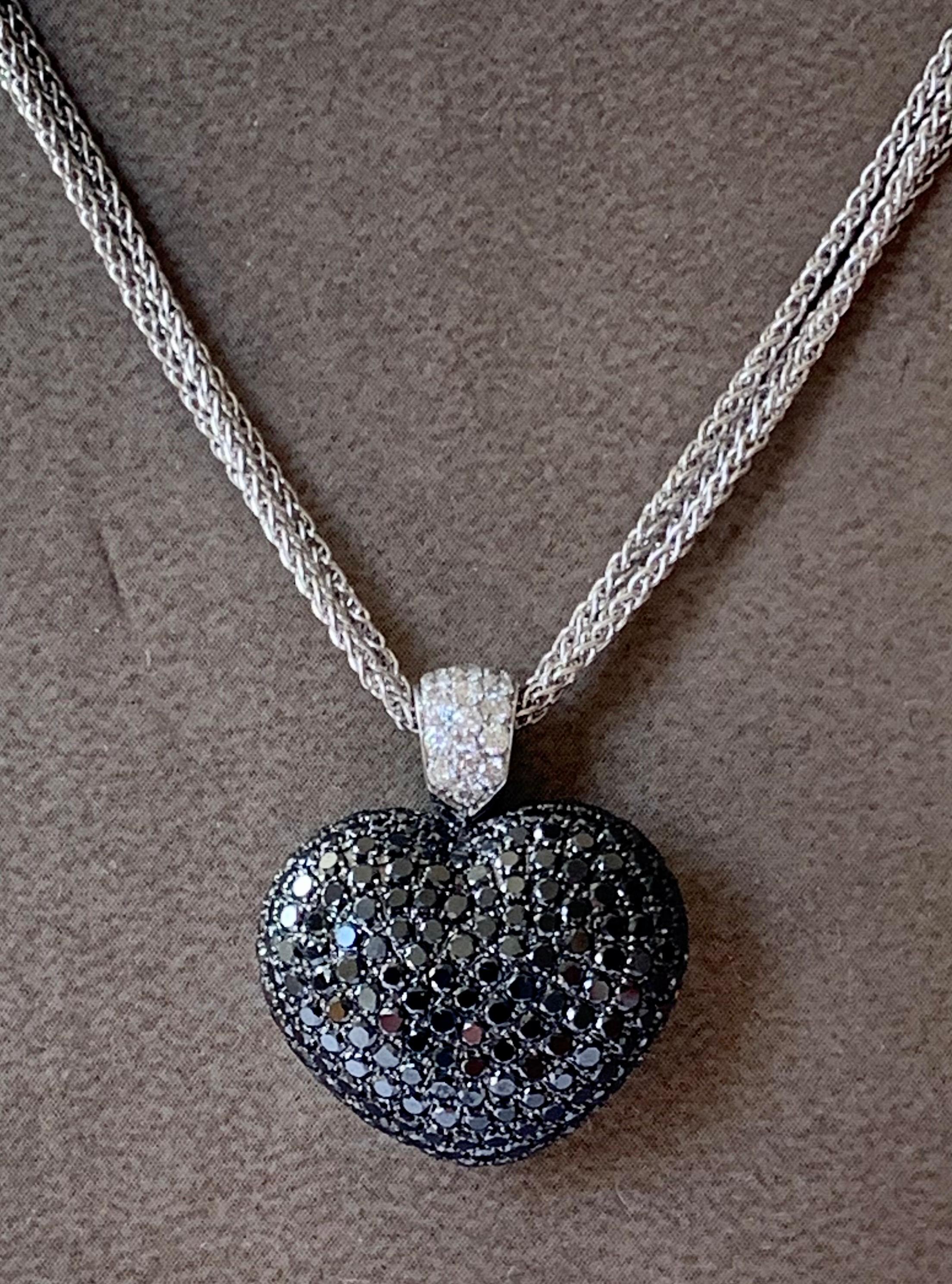 A 18 K white Gold necklace consisting of 3 individual chains with a heart pendant set with brilliant cut black Diamonds with a total weight of approximately 4 ct. The pendant is suspended on a diamond encrusted bale made with 18 K white gold. 16