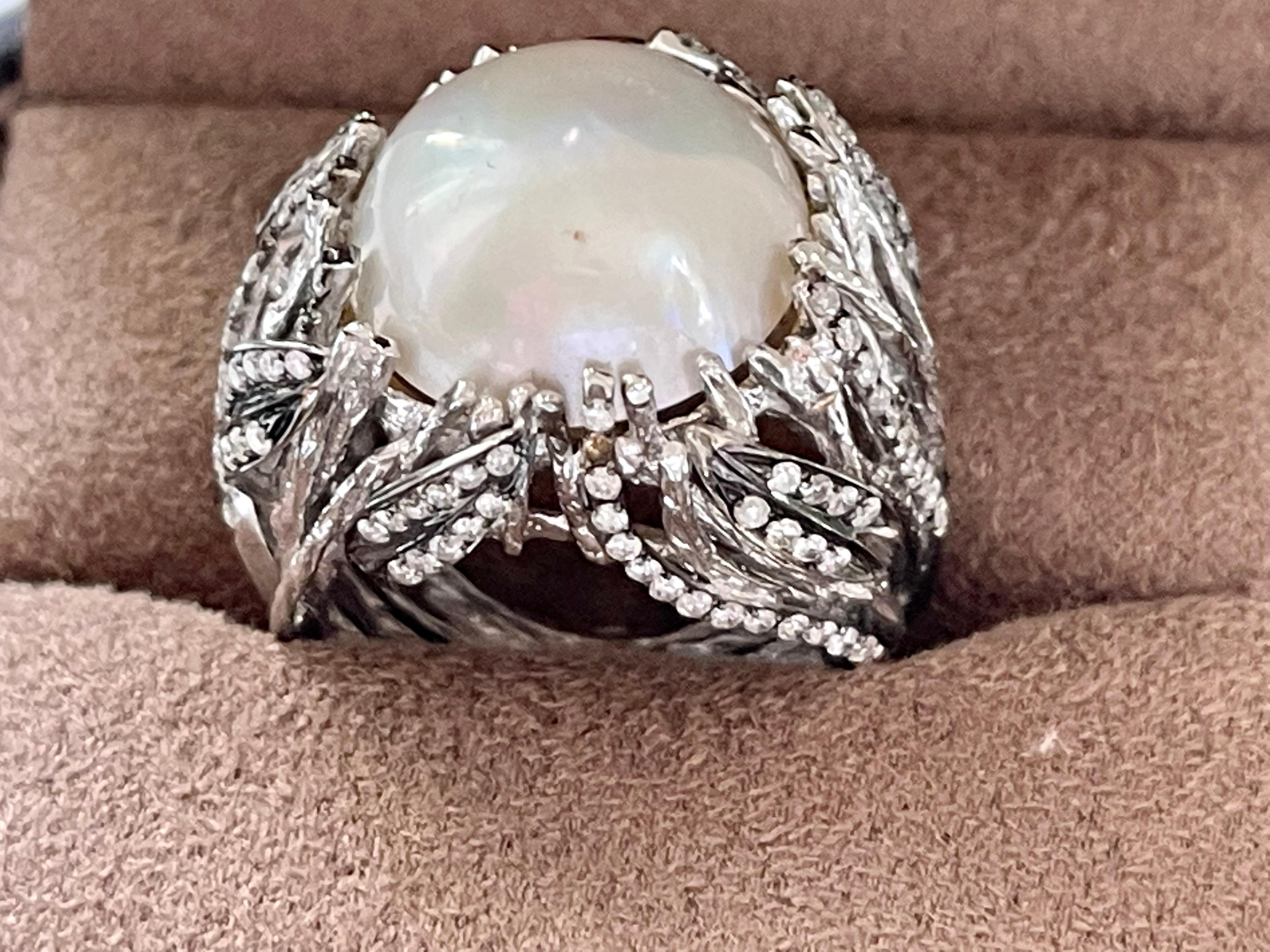 A lovely 18 K white Gold (partially black Rhodium to create a dramatic look) Cocktail Ring featuring a white Mabe Pearl ( Diameter ca. 16 mm) held by white gold tangled wires giving it anorganic and unique appearance.  Some of them are set wtih 131