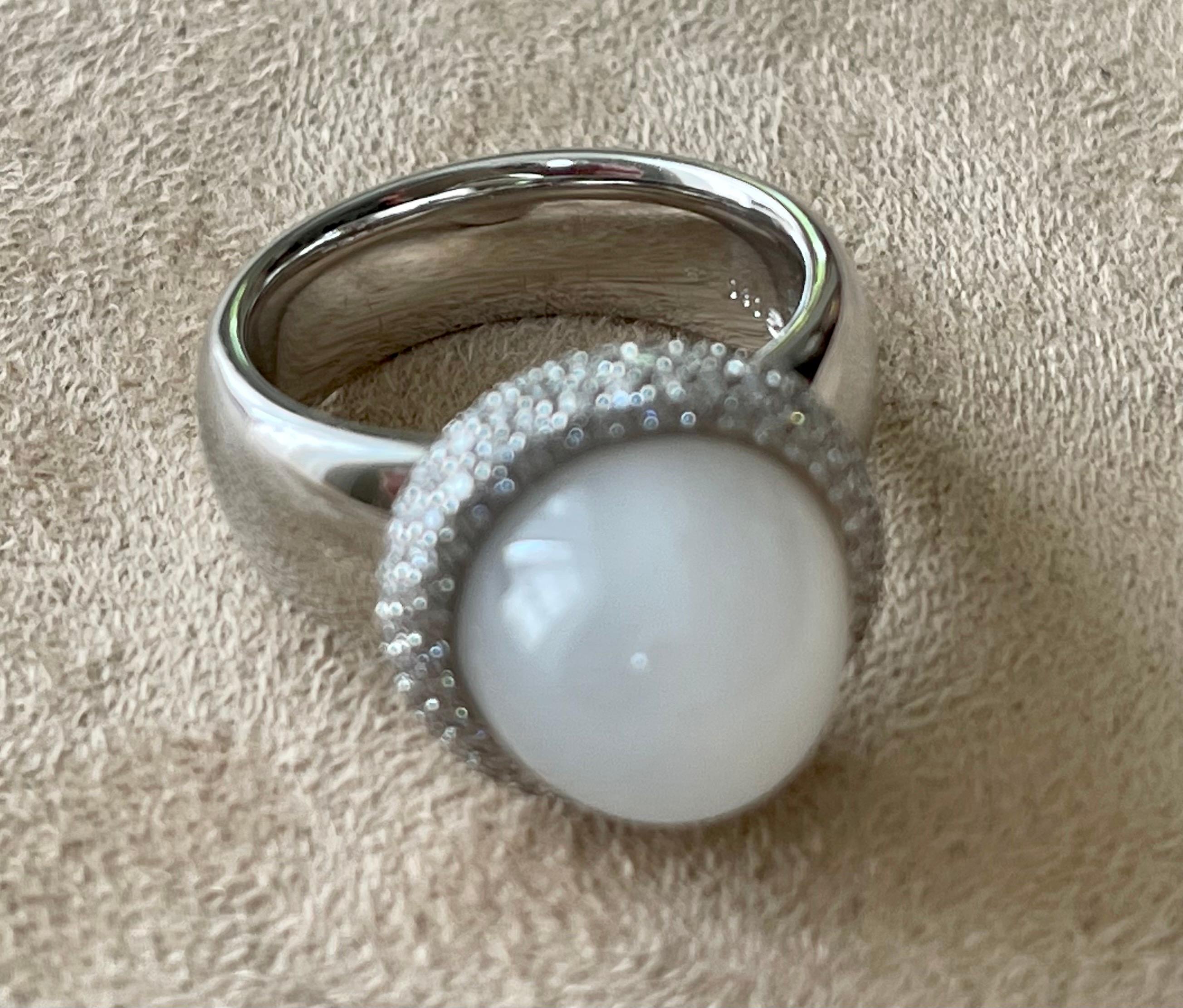 This fabulous Cocktail Ring in 18 K white Gold features a sugarloaf Moonstone Cabochon weighing 8.50 ct and is modernly surrounded by brilliant cut Diamonds with a total weight of 0.80 ct, G color, vs clarity. It is signed Gübelin Lucerne,