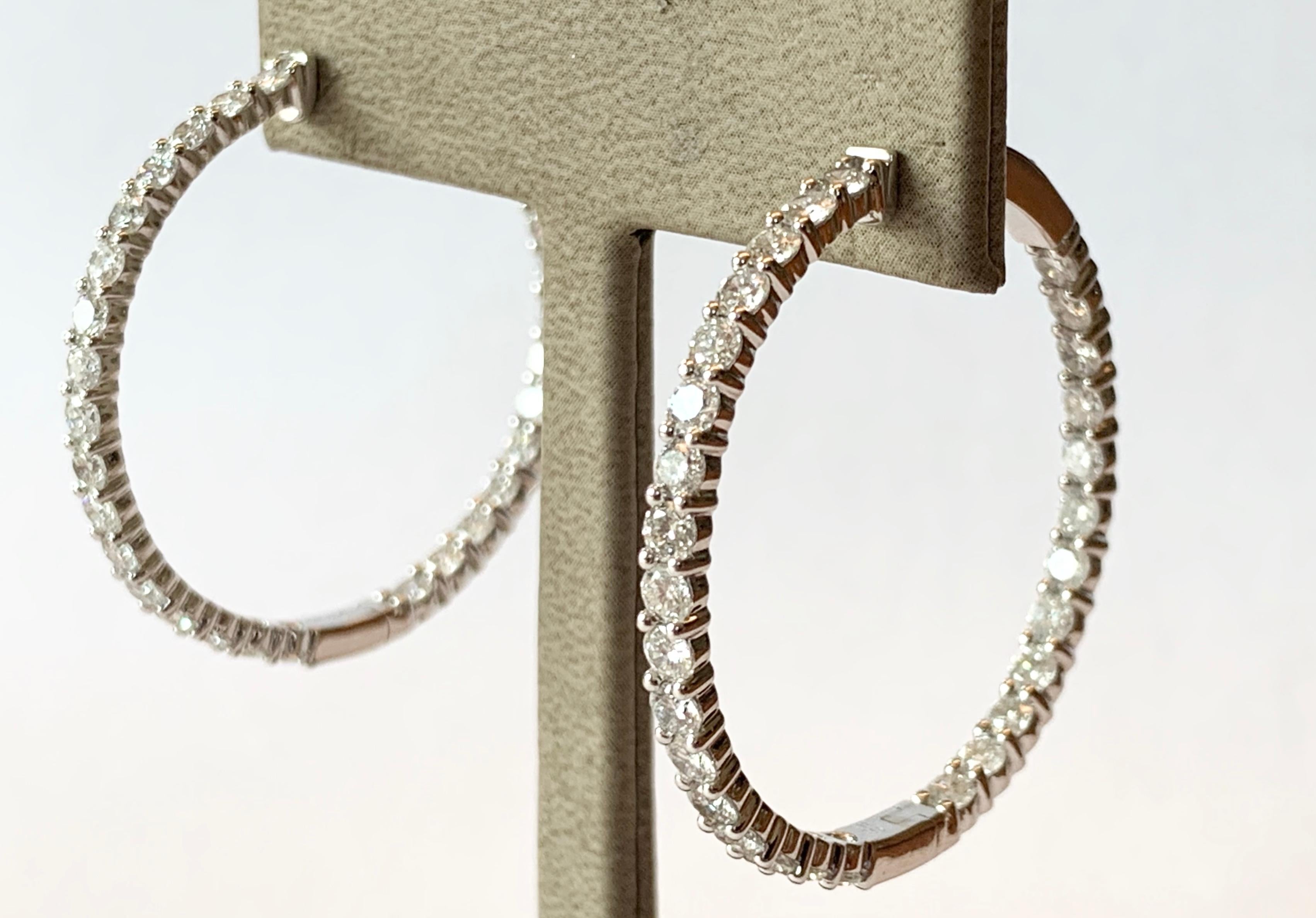 18K white gold inside/outside diamond hoop earrings. There are a total o f58 round diamonds totaling 4.81 carats; they are H in color and si in clarity. Measure 3.9 cm. For pierced ears.