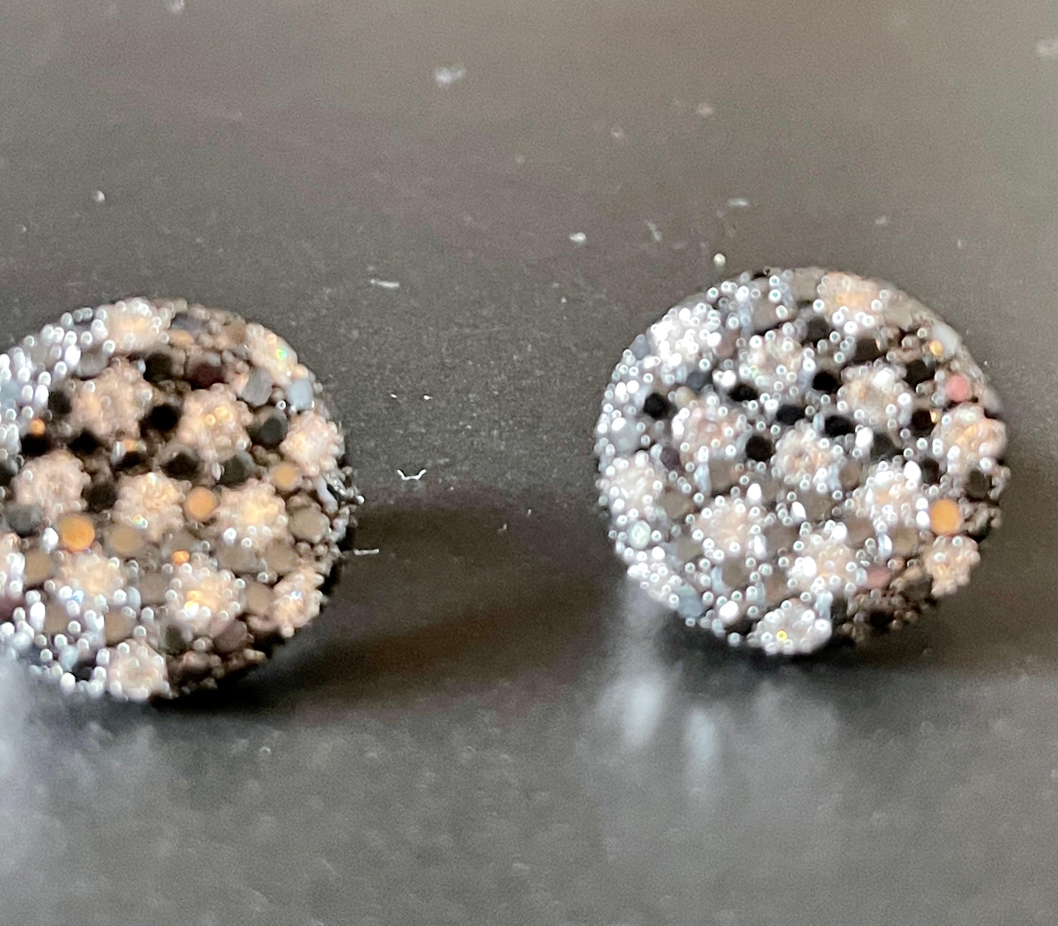 Unusual 18 K white Gold omega clip post earrings, slightly concave shape and pave set with 28 white brilliant cut Diamonds weighing 0.83 ct, G color, vs clarity and 162 brilliant cut black Diamonds with a total weight of 3.89 ct. 
The color