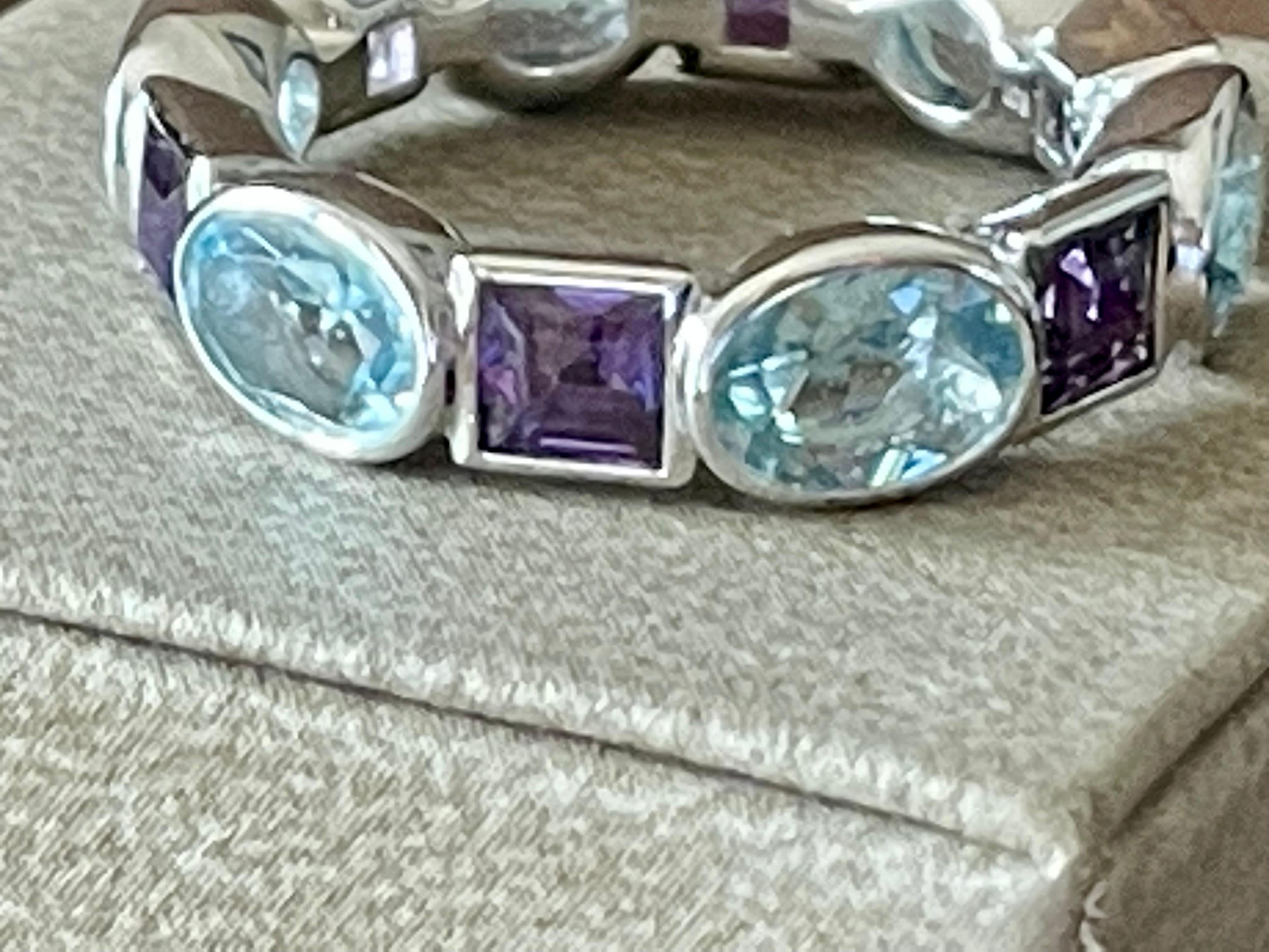 Moderna e solida fascia per l'eternità in oro bianco 18 K con 6 acquamarine ovali incastonate con un peso totale di 3,28 carati e 6 ametiste a taglio quadrato con un peso di 1,79 carati. 
L'anello è attualmente di misura 55/15 (misura americana 7,5)