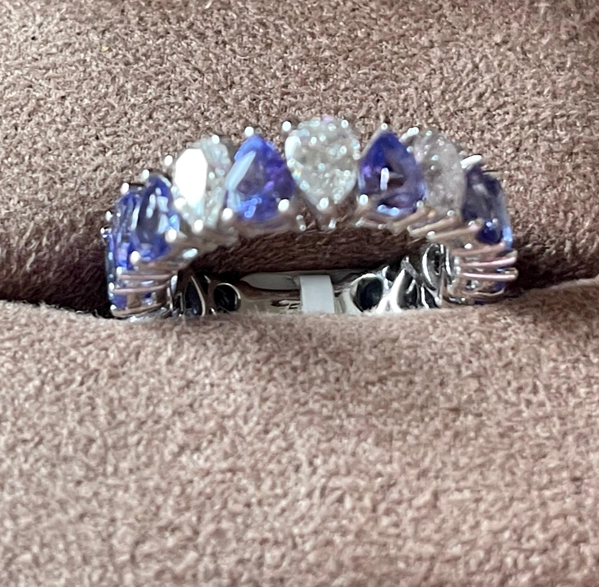 An exquisite find. This 18 K white gold prong set eternity ring features 14 pear shape Tanzanites with a total weight of 4.26 ct and 3 pear shape DIamonds weiging 0.99 ct, J color, I 1 clarity. Width of ring measures 6.1 mm at widest point and