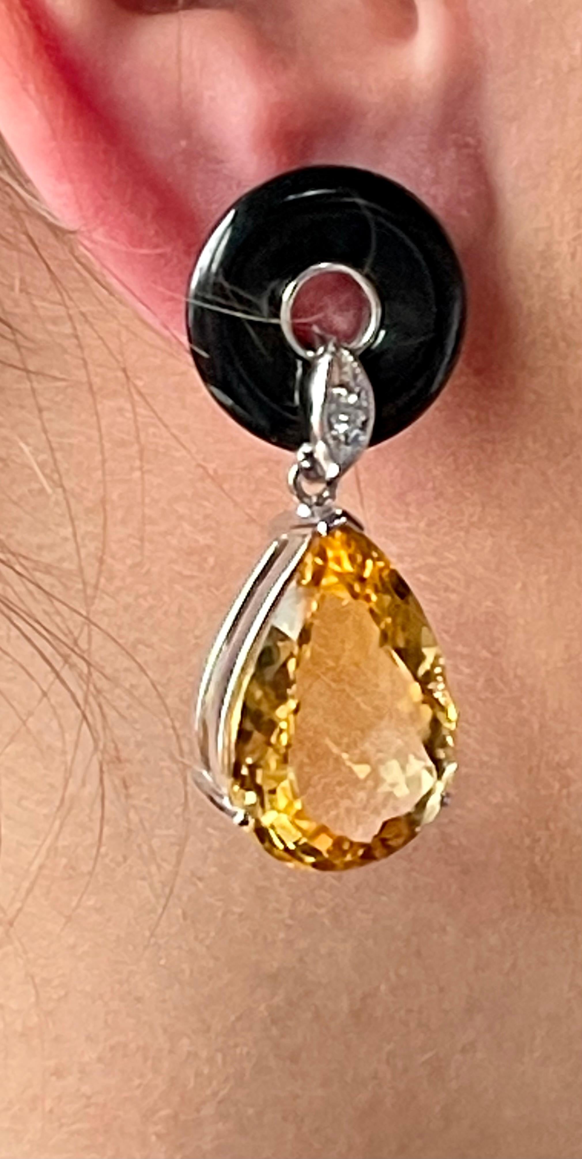 A pair of extravagant 18 K white Gold dangle earrings featuring 2 black donut shaped Onyx, 2 small Diamonds and 2 large pear shape Citrine pendants. The 2 Citrine weigh approximately 
30 ct. 
Masterfully handcrafted piece! Authenticity and money