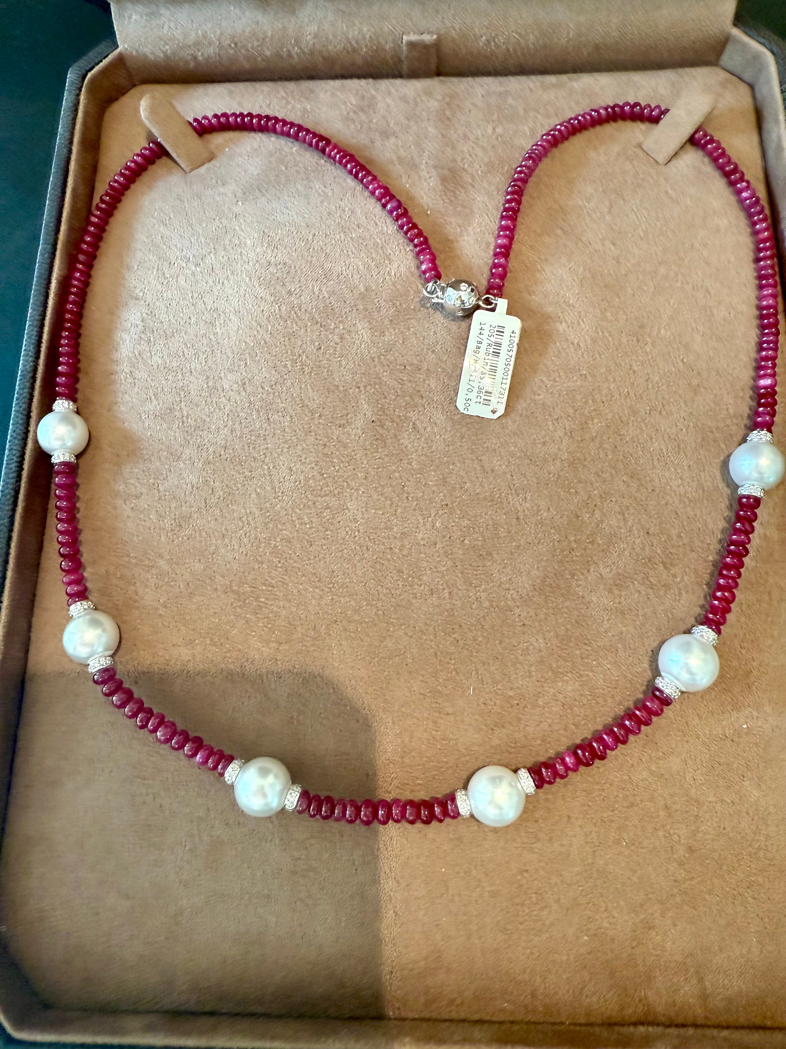 Ce ravissant collier contemporain de perles de rubis avec des diamants ronds et 6 perles blanches des mers du Sud (diamètre 10,5 mm).  présente des rubis d'un poids total de 85,36 carats, façonnés et polis sous forme de perles lustrées pour mettre