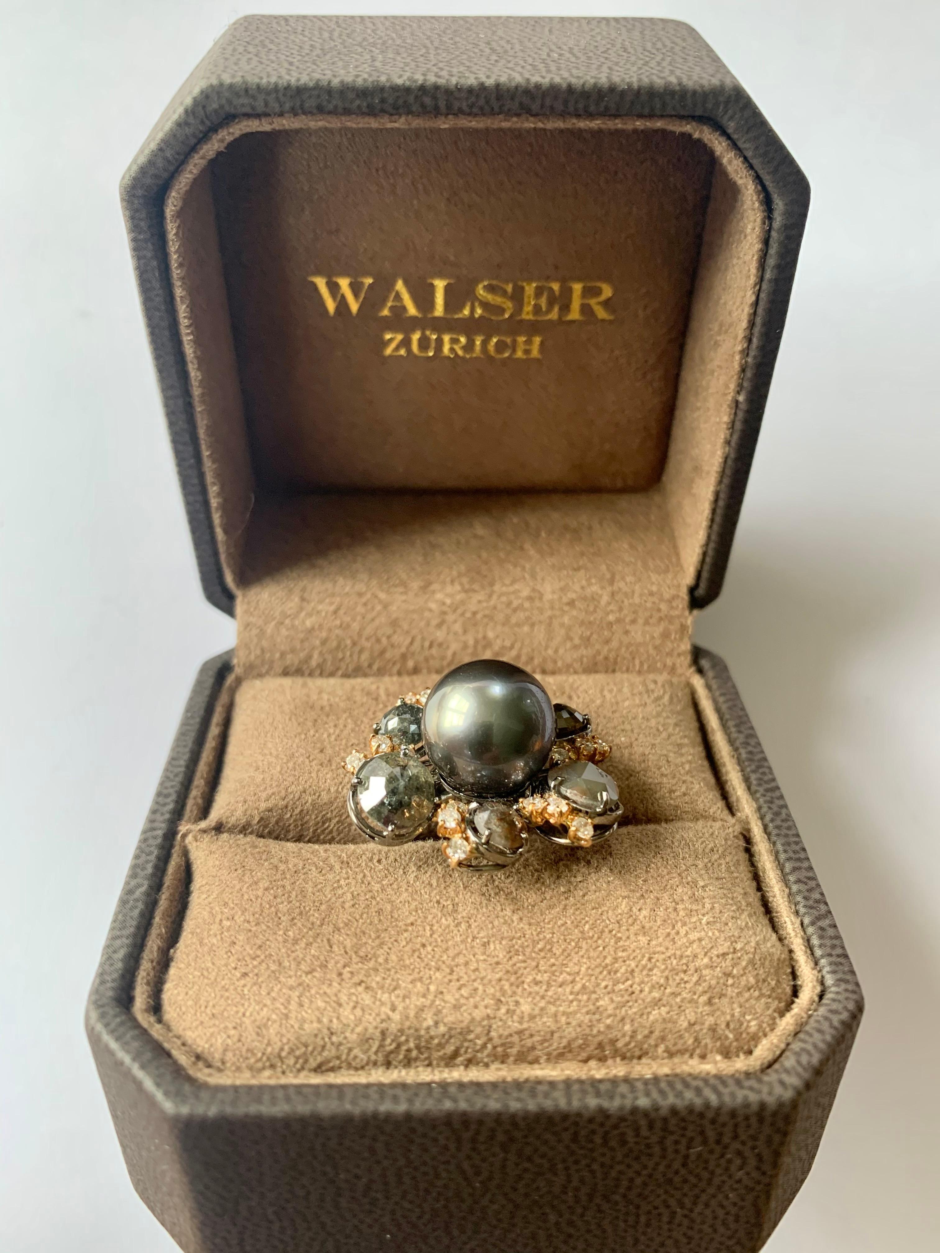 Très inhabituelle bague en or blanc noirci et or rose 18 carats avec 1 perle de Tahiti argentée (12,2 mm). La perle de culture est mise en valeur par 6 diamants bruts d'un poids de 5,45 ct et 18 diamants taille brillant d'un poids de 0,50 ct. 
La
