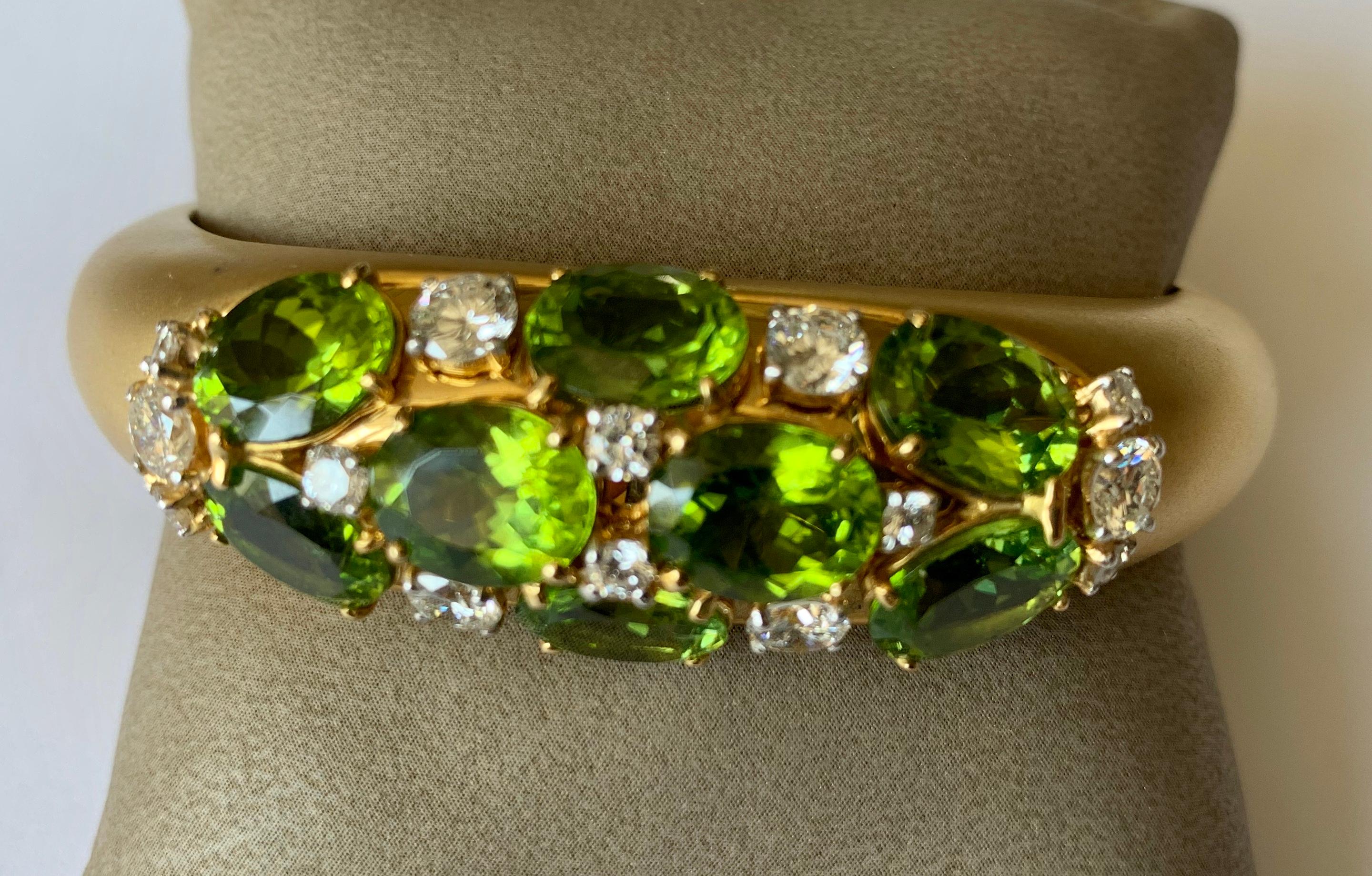 This tapered cuff bracelet fits snugly over the wrist. This beautiful brushed yellow gold bracelet is set with 8 faceted Peridots weighing 21.71 ct and 14 brilliant cut diamonds totaling 2.98 ct. Exquisite workmanship! 