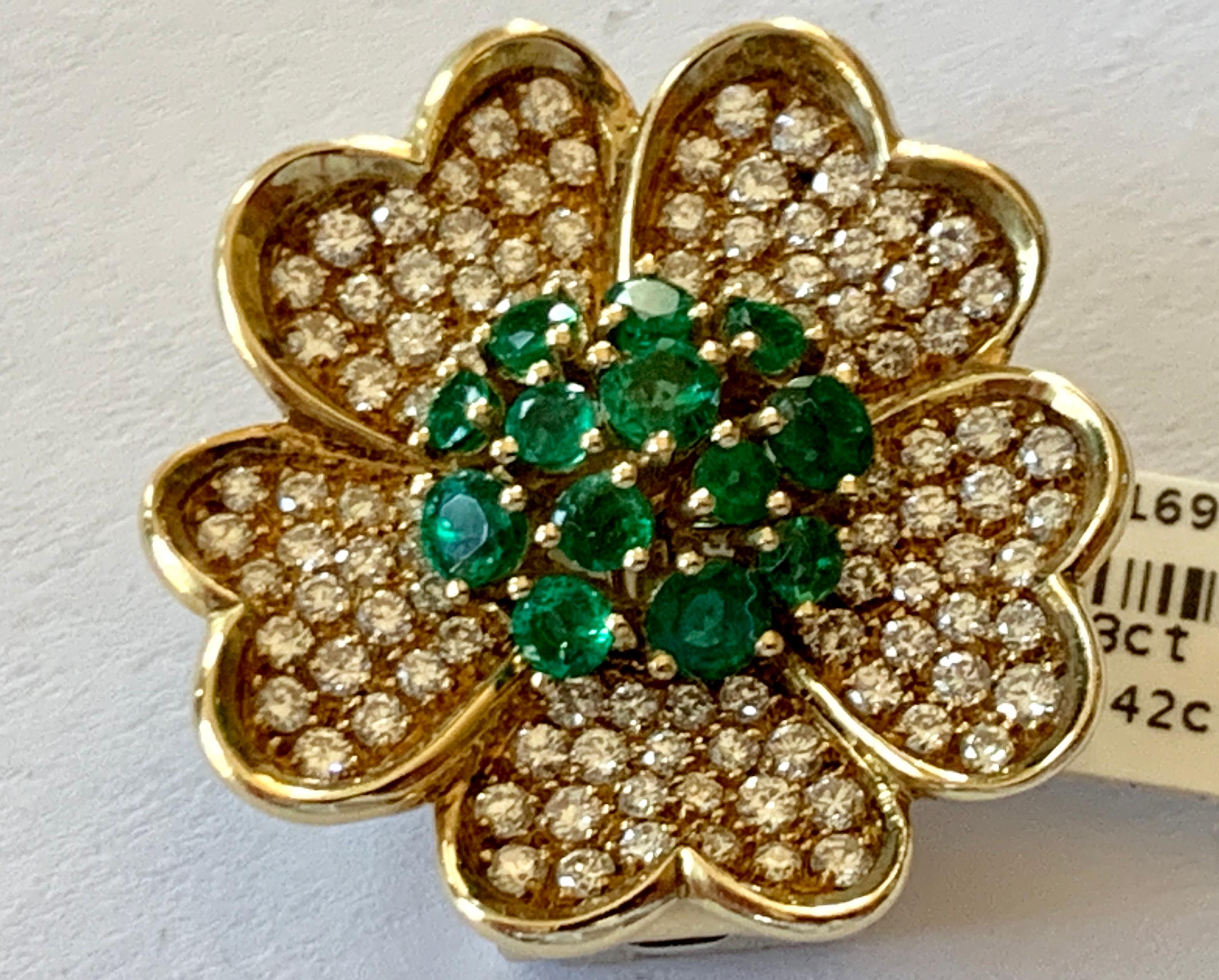 A 1980's  stylized flower brooch/pendant in 18k gold. The brooch is set with Emeralds weighing 1.23 ct and brilliant cut Diamonds totaling 1.42 ct. 
