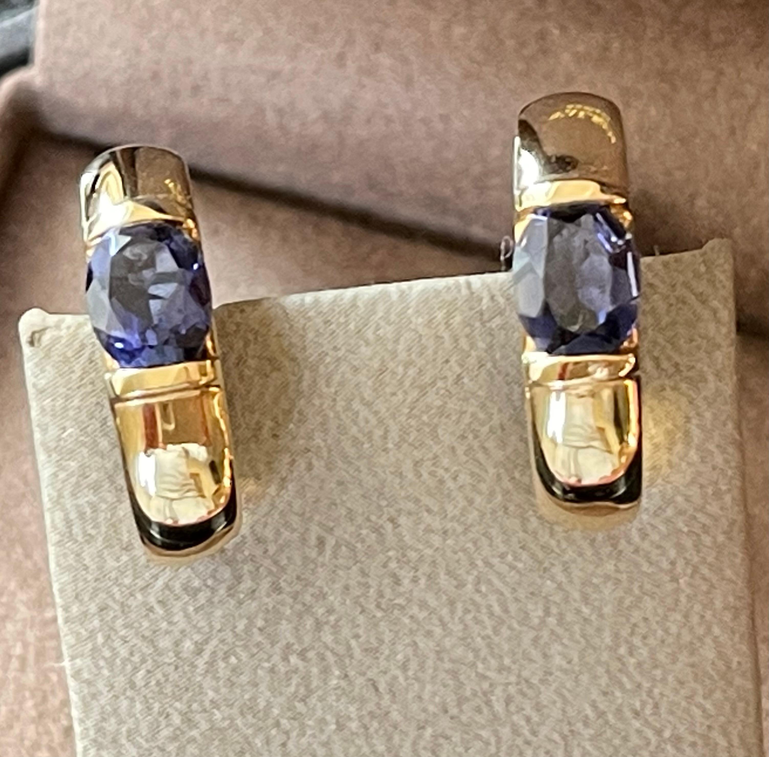 
    Hoop style earrings, each centering an oval cut Iolite, total weight approximately 2.00 carat, bright deep blue and very well matched 
    Iolites are bezel set at the top and bottom, set in 18 K  high polished yellow Gold.
    Post and lever