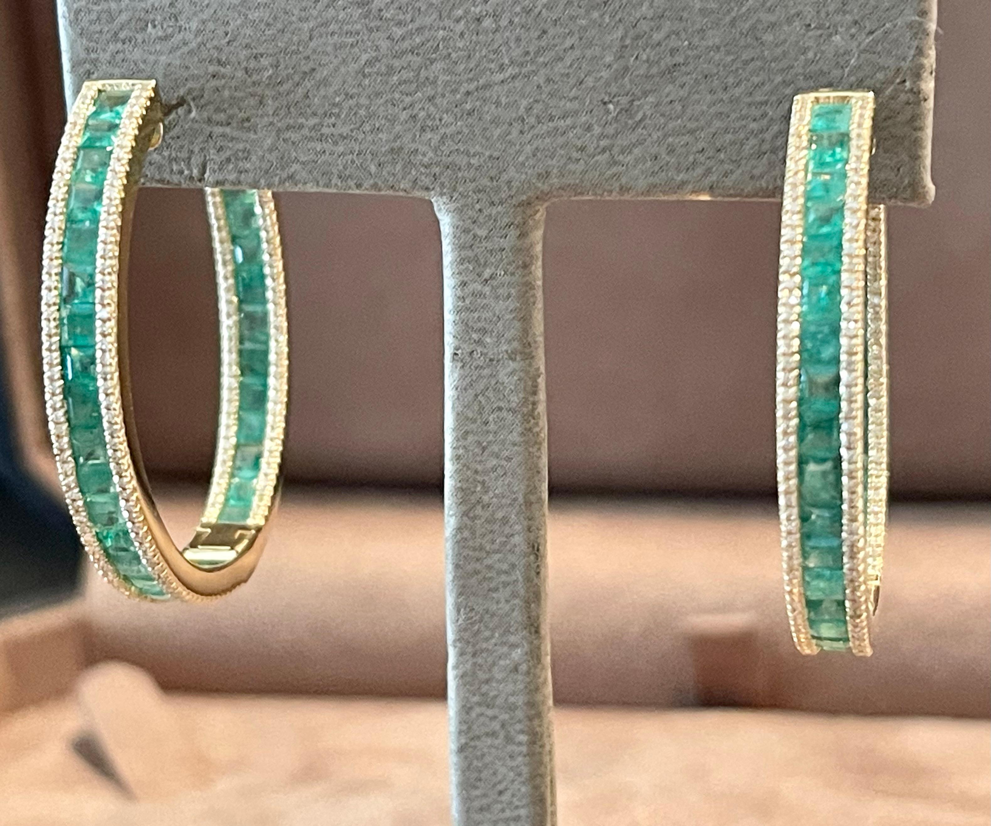 These beatiful inside out hoop earrings are cast in 18 K yellow Gold and are hand set with 69 emearld cut Emeralds with a total weight of 5.70 ct and 392 sparkling brilliant cut Diamonds weighing 0.54 ct. 
They are 3.70 cm long and 0.46 cm wide.