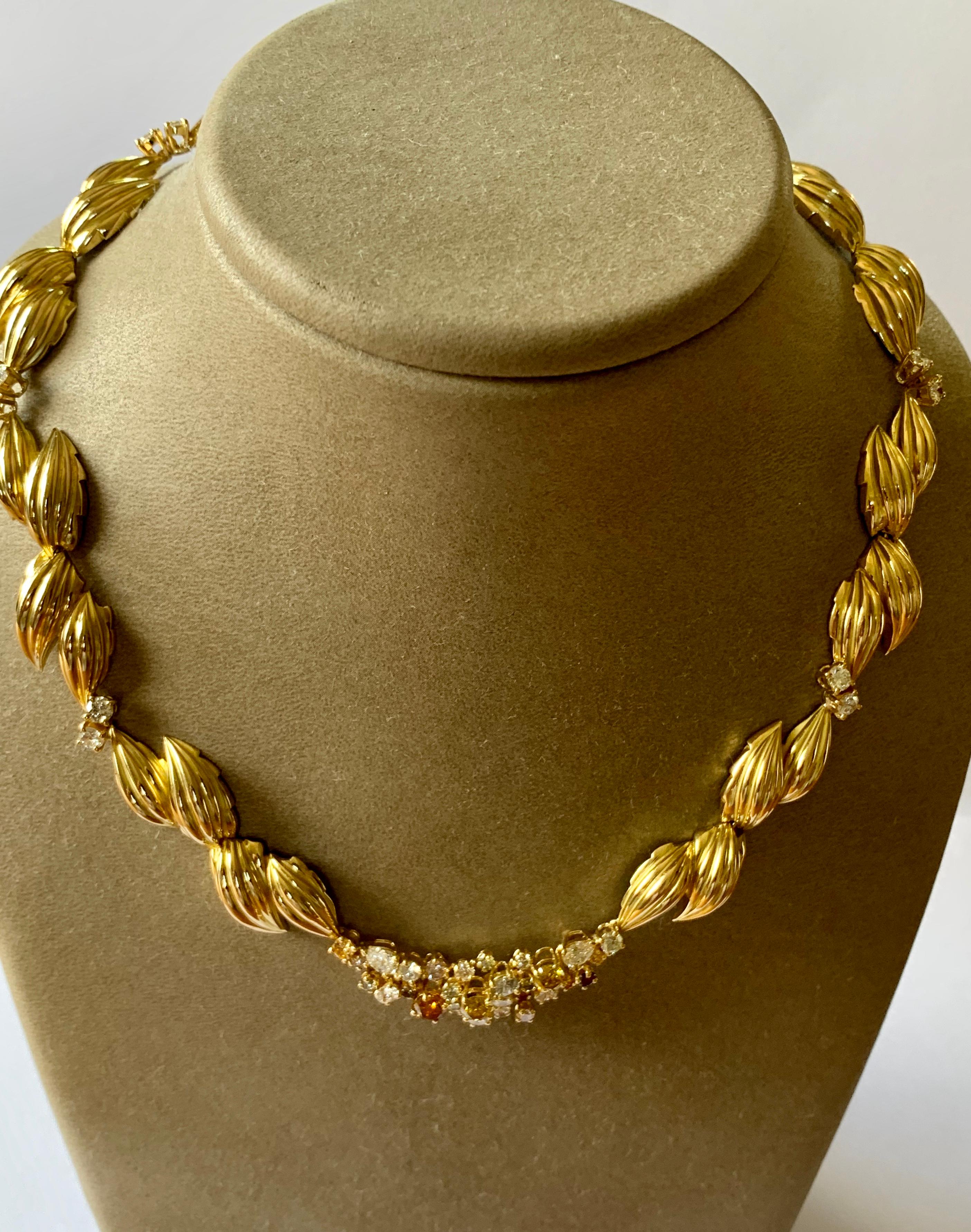 A masterfully crafted necklace with a leaf design from solid 18 Karat Yellow Gold. It is accentuated with 46 white and fancy colored Diamonds weighing circa 5.60 ct. The necklace measures approximately 16 inches in length by 3/4 inches in width.