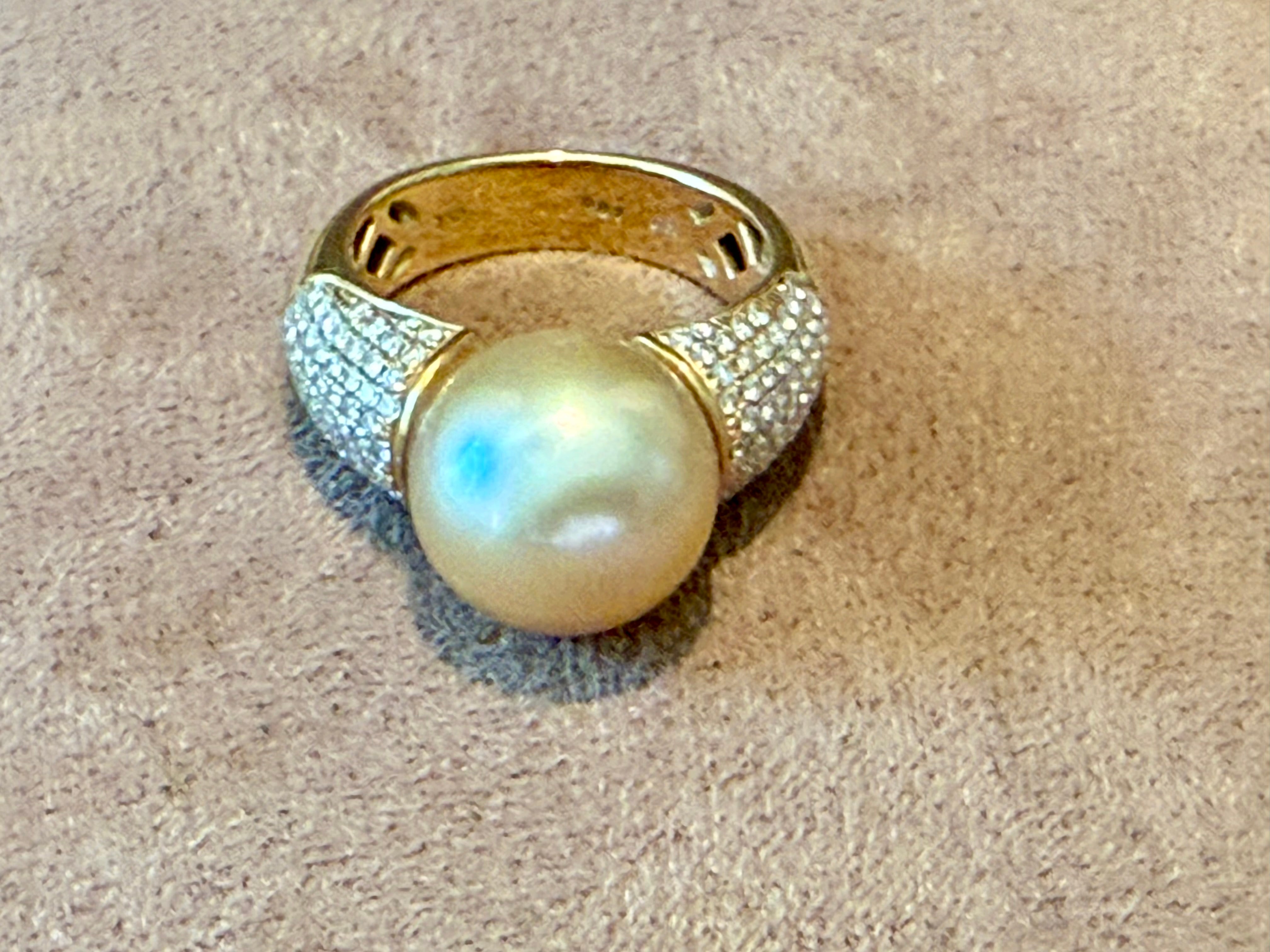 Un sofisticado anillo de oro amarillo de 18 quilates, adornado con numerosos diamantes redondos talla brillante de 0,87 quilates.  en un refinado engaste pavé. Color Grado I, claridad si.  El anillo presenta una fina perla dorada cultivada de los