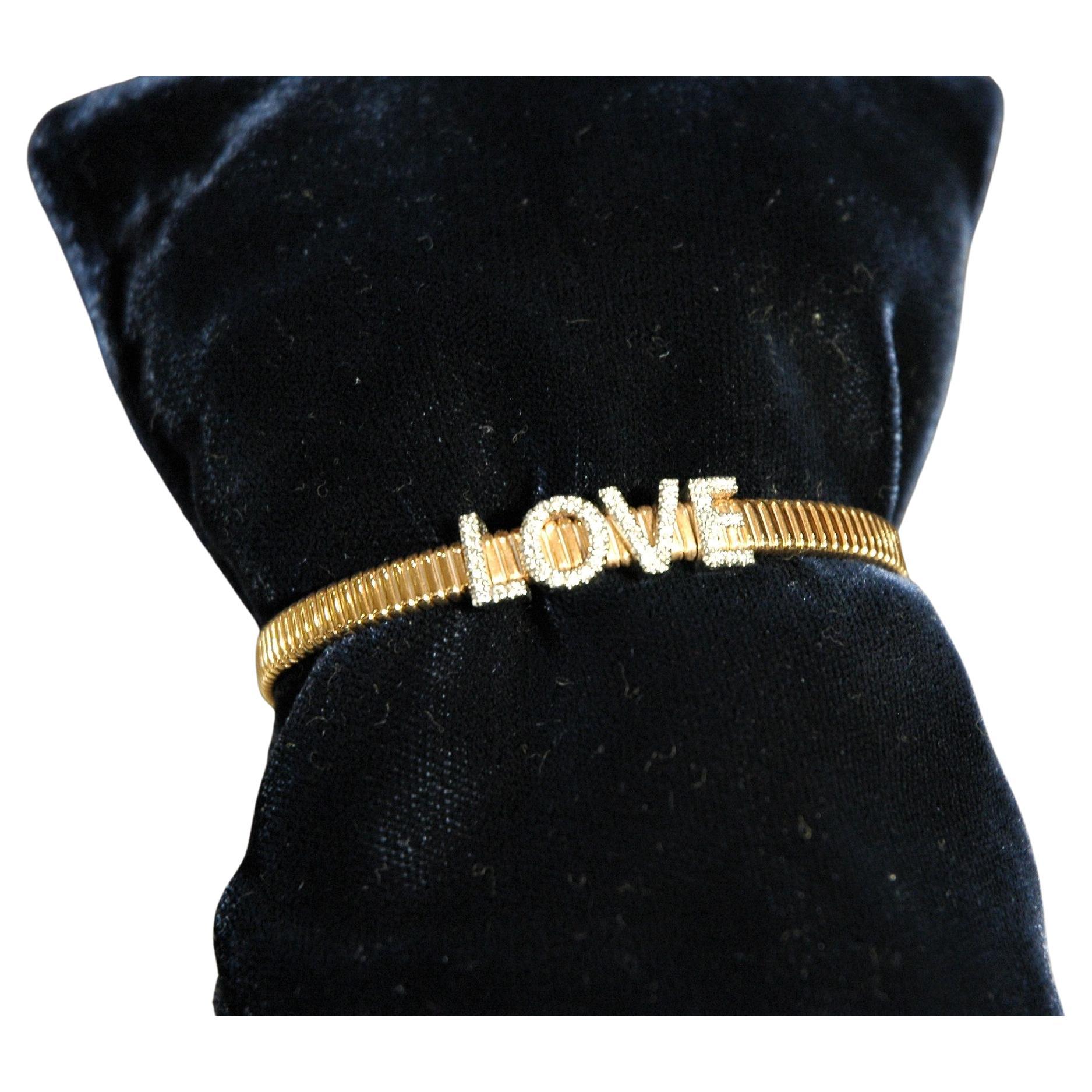 Bracelet semi-rigide en or jaune avec l'écriture LOVE avec diamants ct. 0.30. Vous pouvez également le porter sur un poignet plus grand, car la structure du bracelet est légèrement élastique. C'est un cadeau parfait pour votre moitié aimante. 