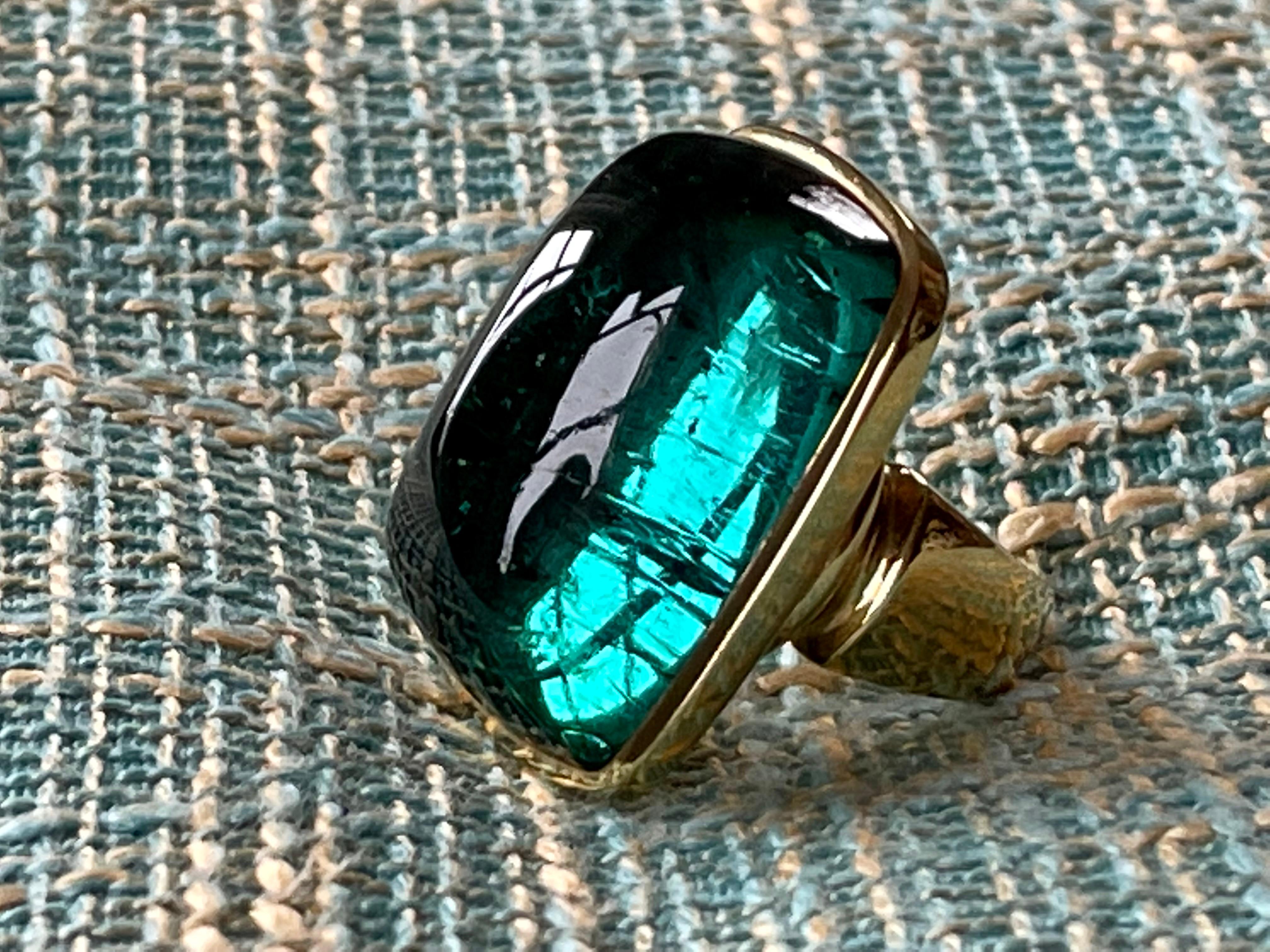 Stunning 18 K yellow Gold Ring featuring a huge bezel set fascintaing green Tourmaline Cabochon. Started in 1967 in London by Leo and Ginnie de Vroomen the company is known for bold and innovative designs. Distinctive from the start, the renowned