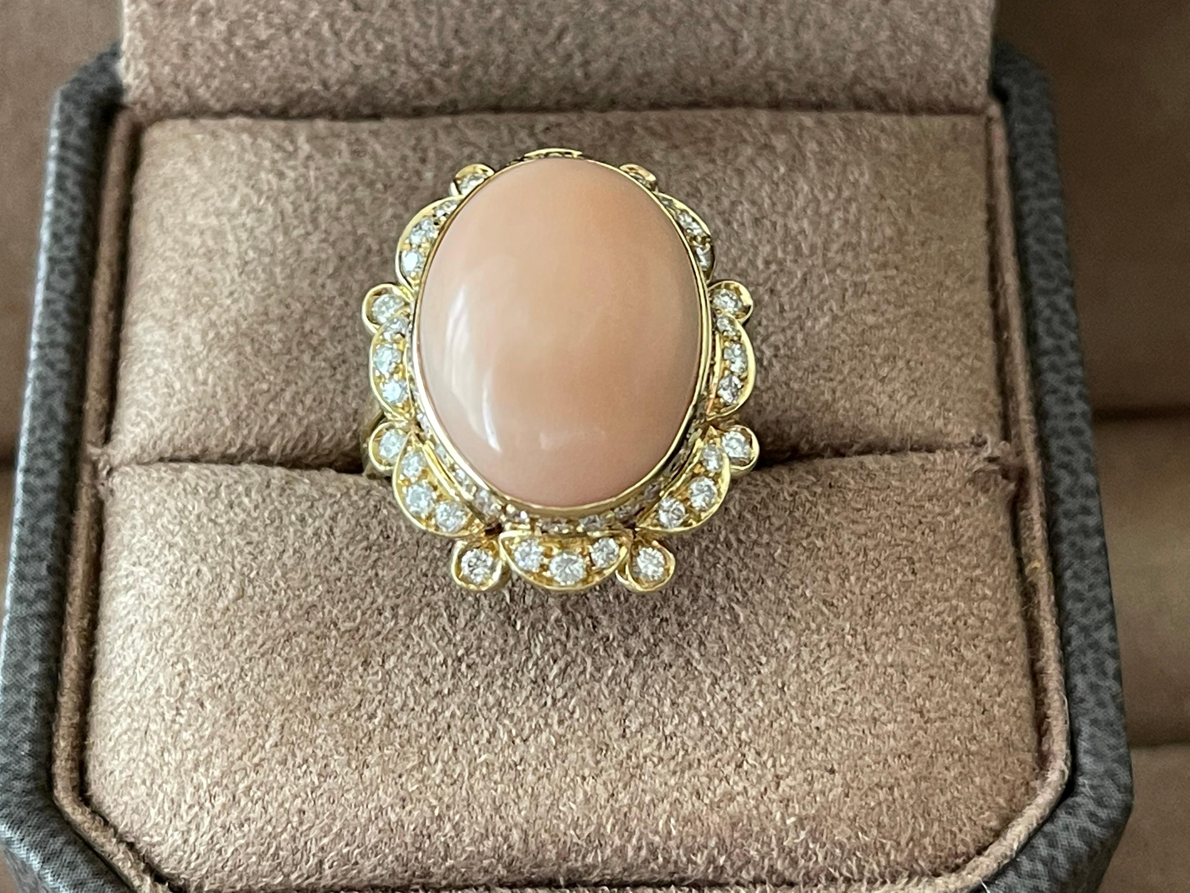 Stylish 18 K yellow Gold Vintage Ring featuring an angel skin Coral Cabochon estimated approximately 8 ct and 64brillinat cut Diamonds weighing approximately 1.28 ct, G color, vs clarity. The 
The face of the ring measures 2.7 cm x 2.1 cm. The ring