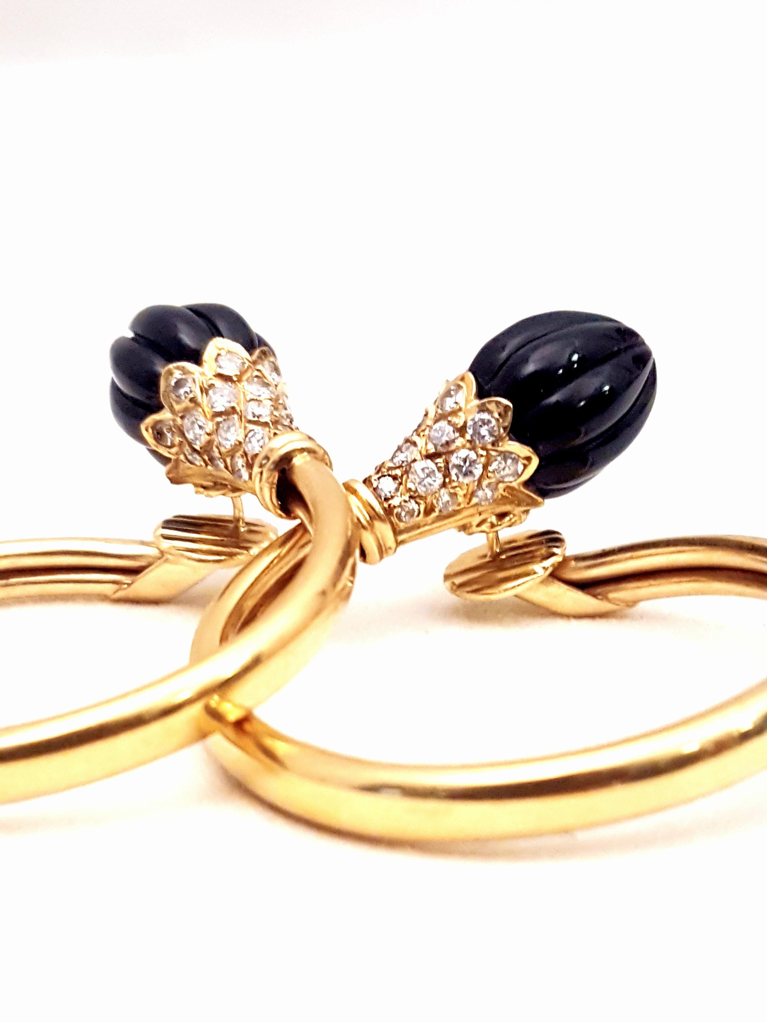 Crafted in France with a flair for the unique!  These 18 karat yellow gold pierced hoop earrings feature fluted black onyx tops supported by white diamond encrusted caps.  Approximate total diamond weight of 0.70 carats.  Posts enter ear from behind