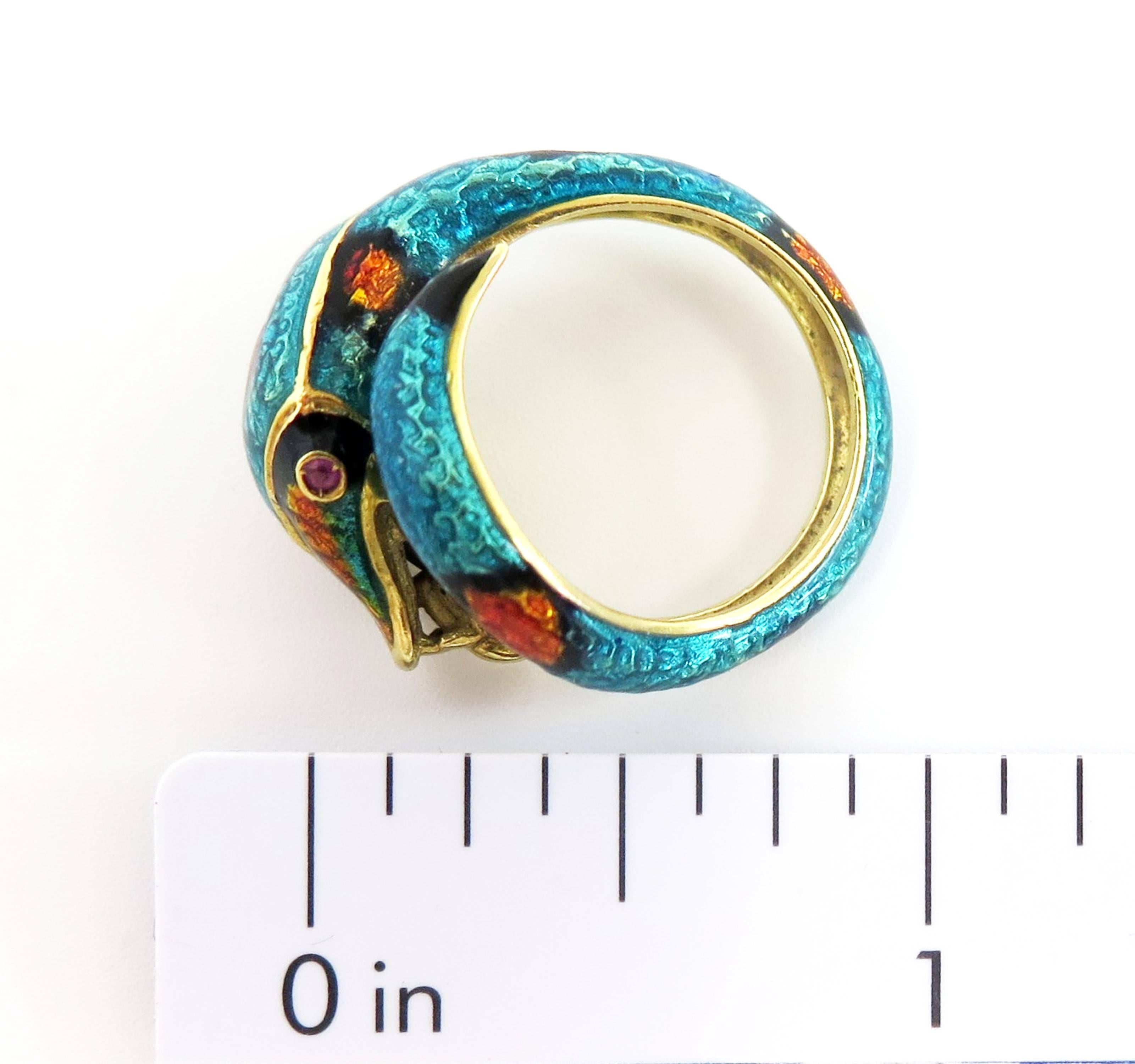 A beautiful serpent, shimmering with unusual turquoise, orange and black enameled scales, with ruby eyes, coils around your finger in this exotic 18 karat yellow gold snake ring. Circa 1960s and Sssensssational!

Size 7 1/2