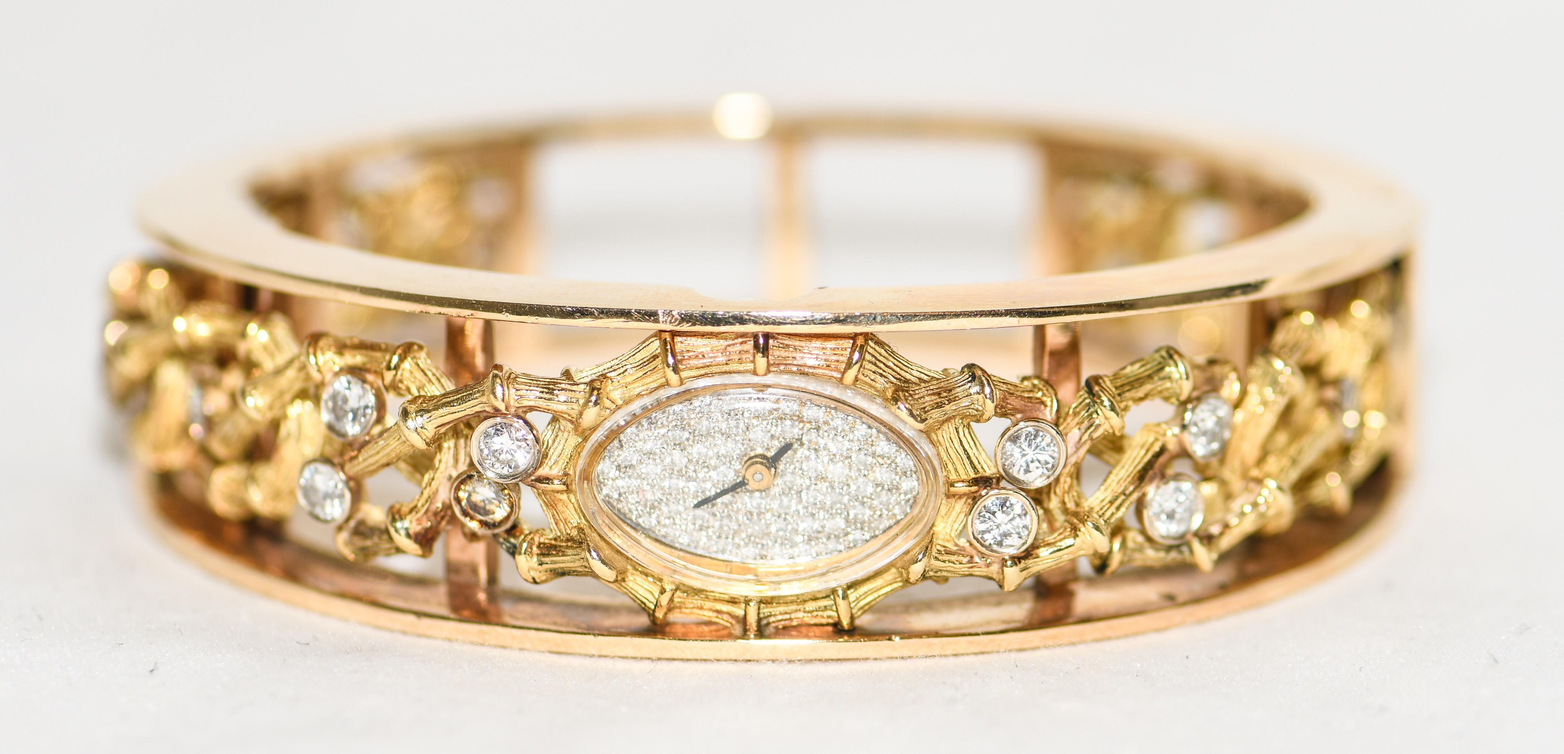 Magnificently crafted in the 1980's with 18 karat yellow gold, this bangle watch is beyond fabulous!  Focal point is the oval, micro pave diamond face watch.  Detailed frame is heavily engraved with markers for time keeping.  Open work resembles the