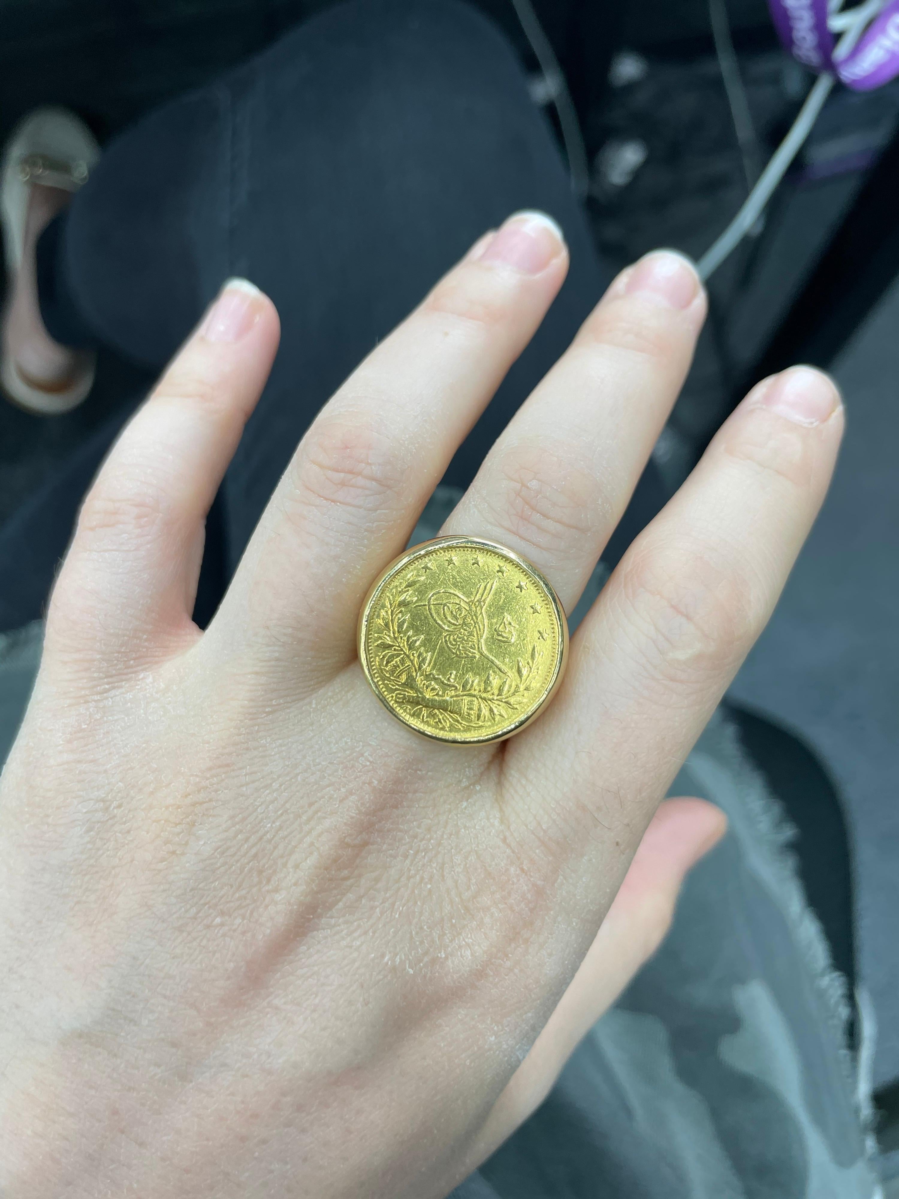 This coin ring features one 21 karat yellow gold coin that reads Arabic number on a 18 karat yellow gold mounting weighing 28.6 Grams.
The coin measures 7/8 inches diameter. 