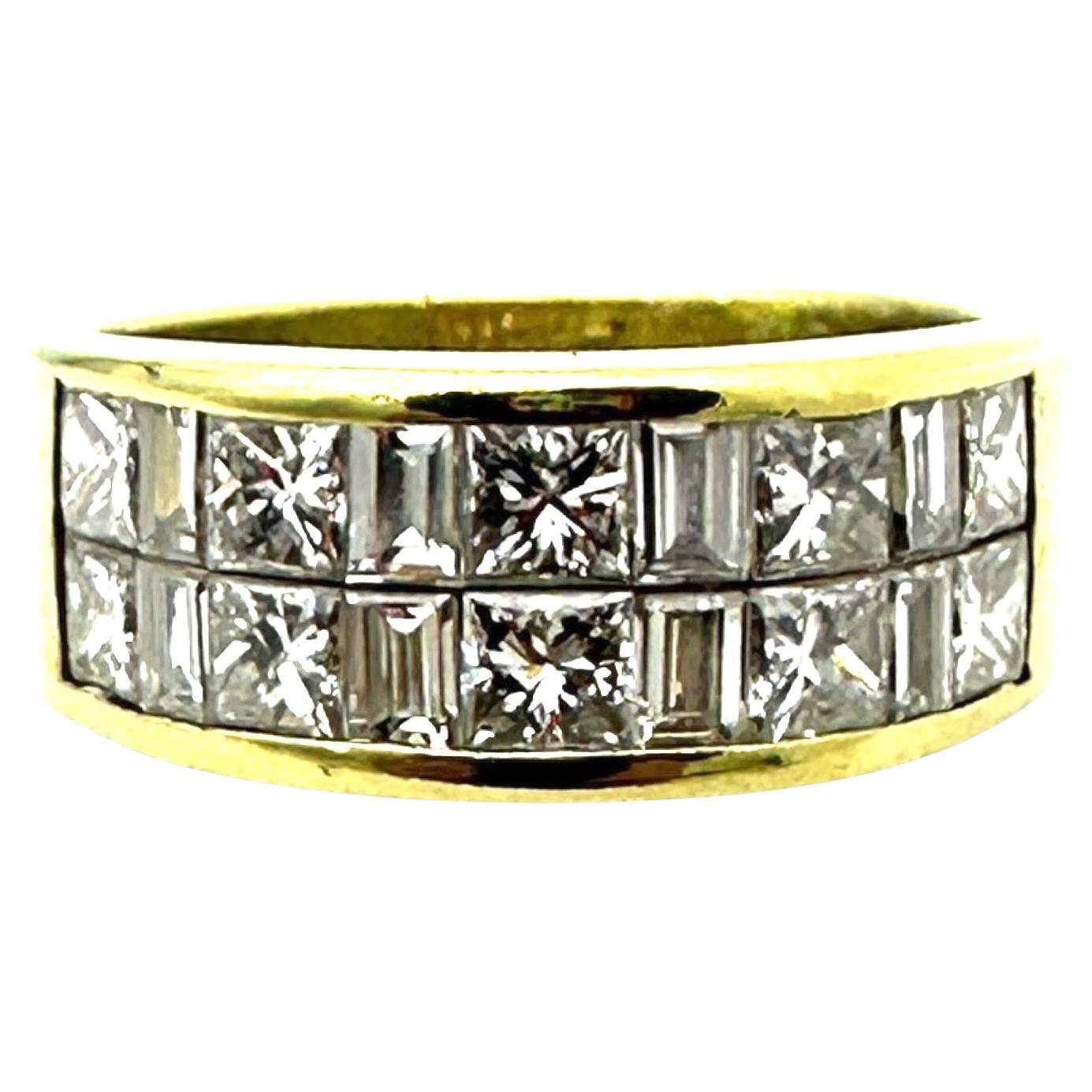 An 18-karat yellow gold band showcasing two rows of meticulously arranged diamonds in a channel-set design. Ten princess-cut stones alternate with eight baguette-cut diamonds, secured within grooved channels that eliminate the need for traditional