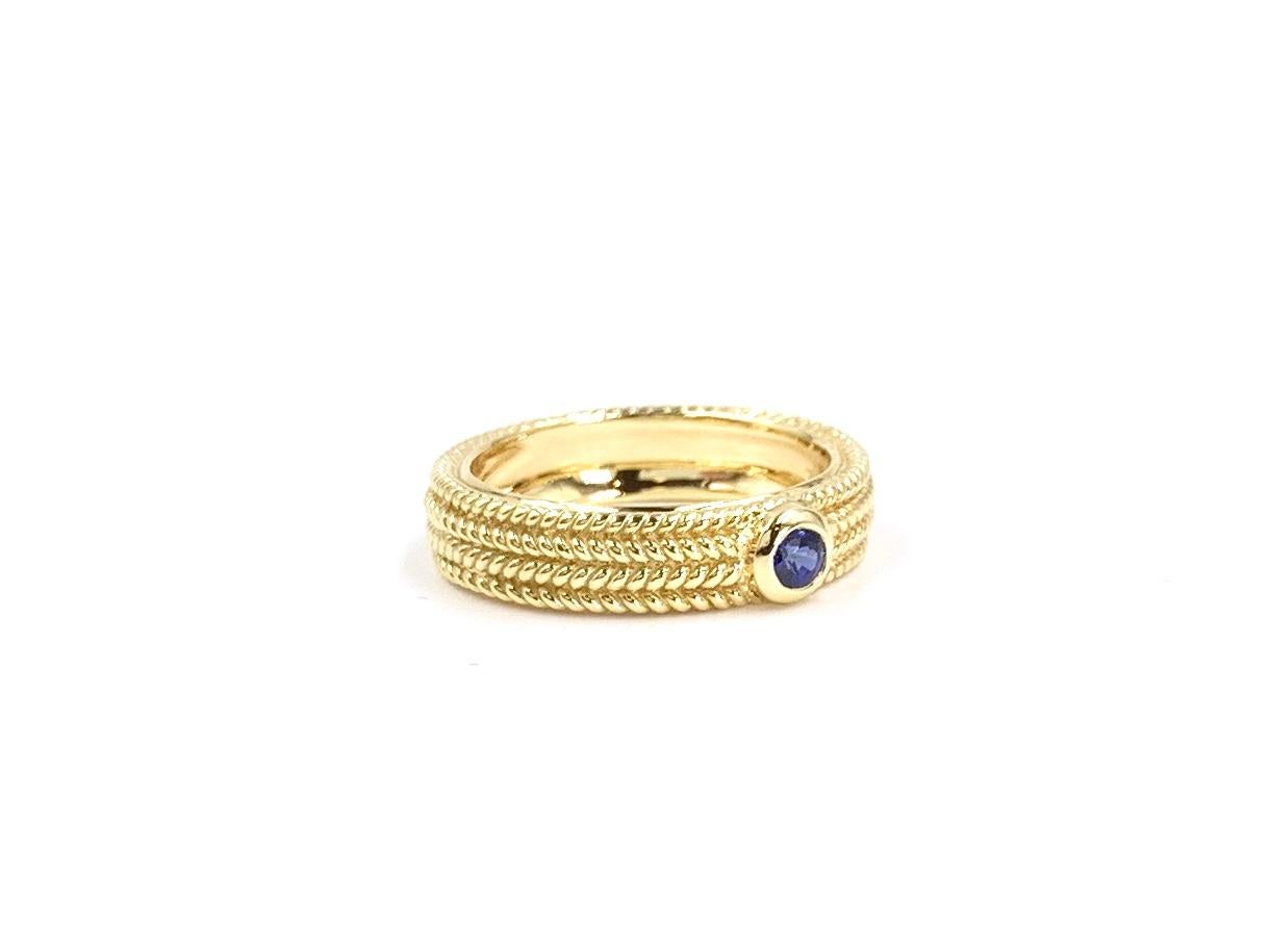 A wearable solid 18 karat yellow gold 5mm ring featuring a beaded design all the way around and a single round .20 bright blue sapphire. Ring can be worn on it's own or will stack nicely with other band style rings.
Finger size 6.5