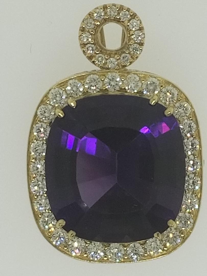 Designed by Michael Engelhardt, this lively deep purple Amethyst of 27.20 carats is set in an 18 Karat yellow gold frame with an open gallery to permit the light to enter and illuminate the stone.  To add to the mounting, there are diamond stations