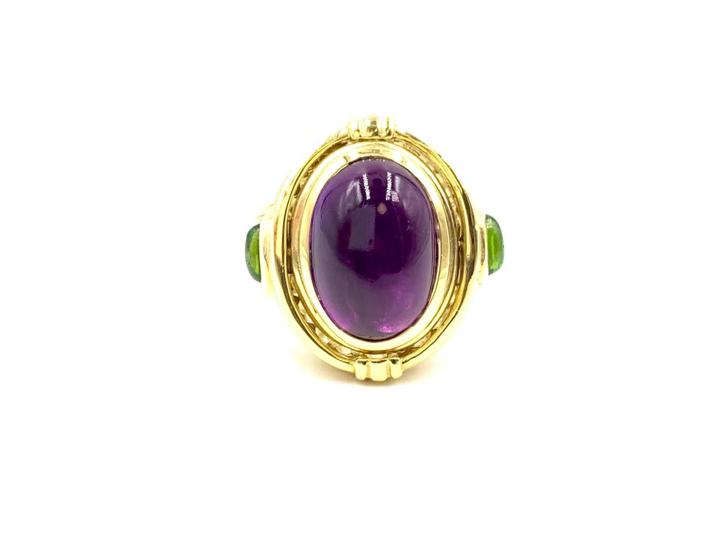 Two stylish looks in one solid 18 karat yellow gold SeidenGang ring. A well saturated bezel set cabochon amethyst can be flipped to show a carved gold Greek inspired relief. An oval cabochon green tourmaline is set on each side of the ring. Gold has