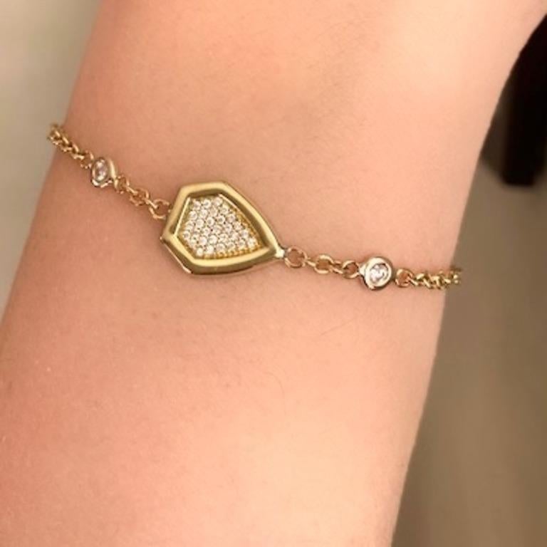 A gold and diamond pave shield, anchored by two larger bezel set diamonds, combines in this unique bracelet.  With a sparkle of diamonds against warm gold, this is a fashionable piece that can be worn with stacks of other bracelets.
An easy to wear